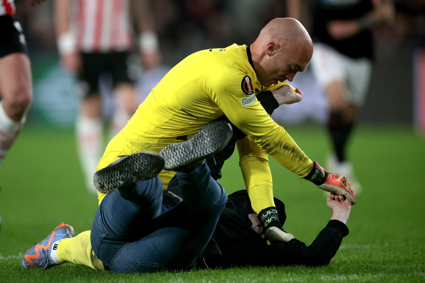 EINDHOVEN - A supporter fights with Sevilla FC goalkeeper Marko Dmitrovic during the UEFA Europa league play-off match between PSV Eindhoven and Sevilla FC at Phillips stadium on February 23, 2023 in Eindhoven, Netherlands. AP | Dutch Height | Jeroen Putmans (Photo by ANP via Getty Images)