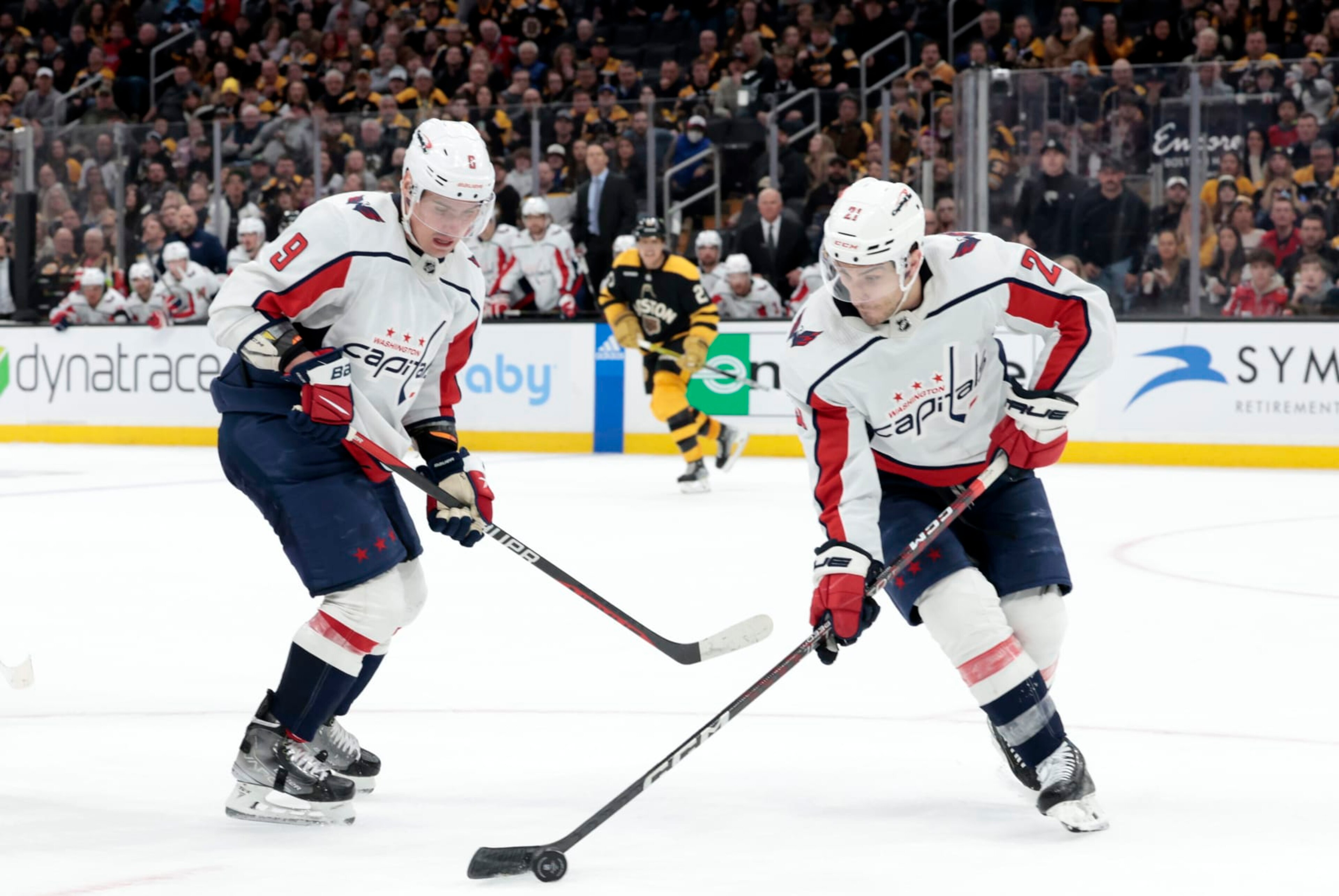 BOSTON, MA - FEBRUARY 11: Washington Capitals right wing Garnet Hathaway (21) grabs the puck watched by defenseman Dmitry Orlov (9) during a game between the Boston Bruins and the Washington Capitals on February 11, 2023, at TD Garden in Boston, Massachusetts. (Photo by Fred Kfoury III/Icon Sportswire via Getty Images) BOSTON, MA - FEBRUARY 11: Washington Capitals right wing Garnet Hathaway (21) grabs the puck watched by defenseman Dmitry Orlov (9) during a game between the Boston Bruins and the Washington Capitals on February 11, 2023, at TD Garden in Boston, Massachusetts. (Photo by Fred Kfoury III/Icon Sportswire via Getty Images)