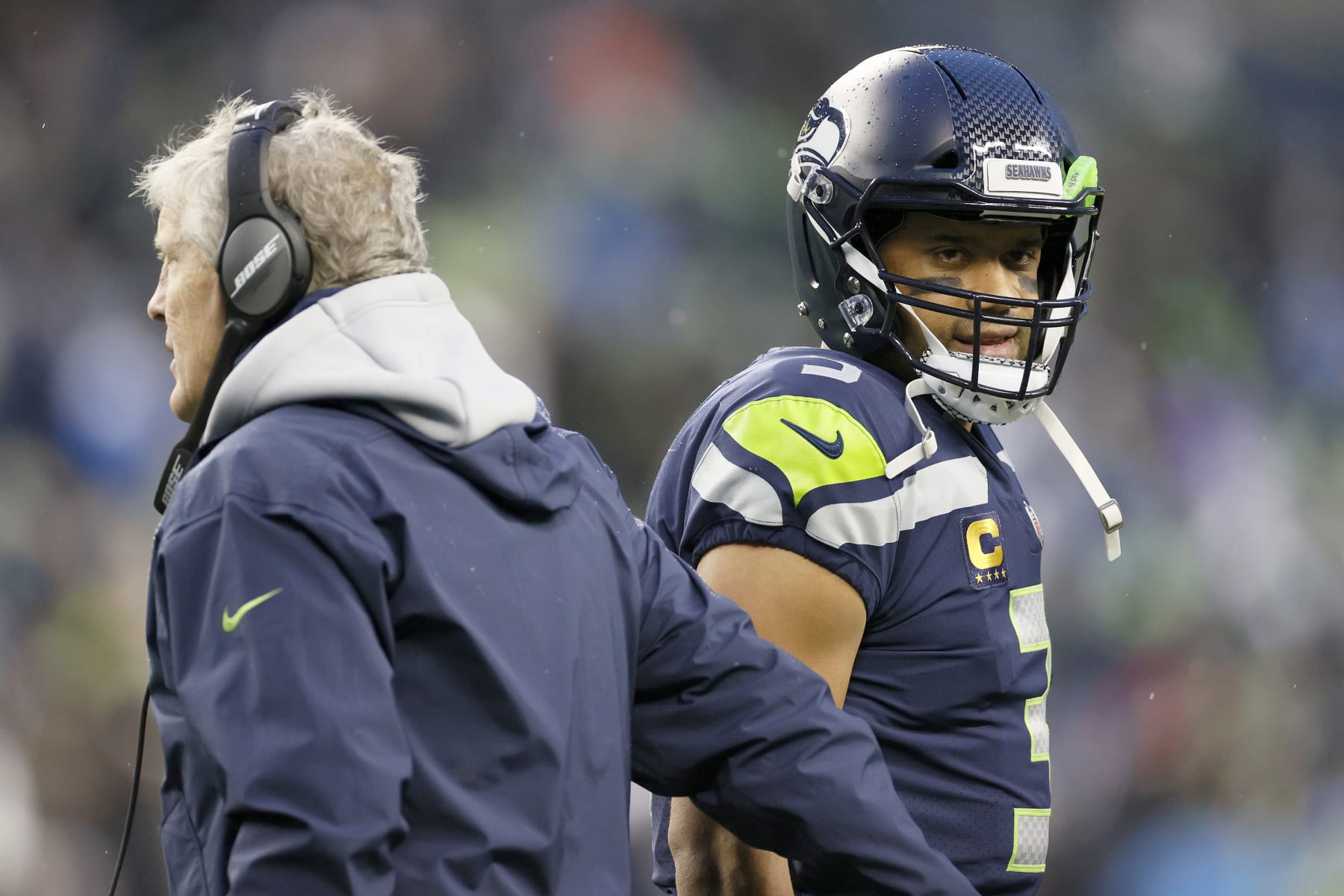 SEATTLE, WASHINGTON - JANUARY 02: Head coach Pete Carroll and Russell Wilson #3 of the Seattle Seahawks interact on the sidelines during the second half against the Detroit Lions at Lumen Field on January 02, 2022 in Seattle, Washington. (Photo by Steph Chambers/Getty Images)