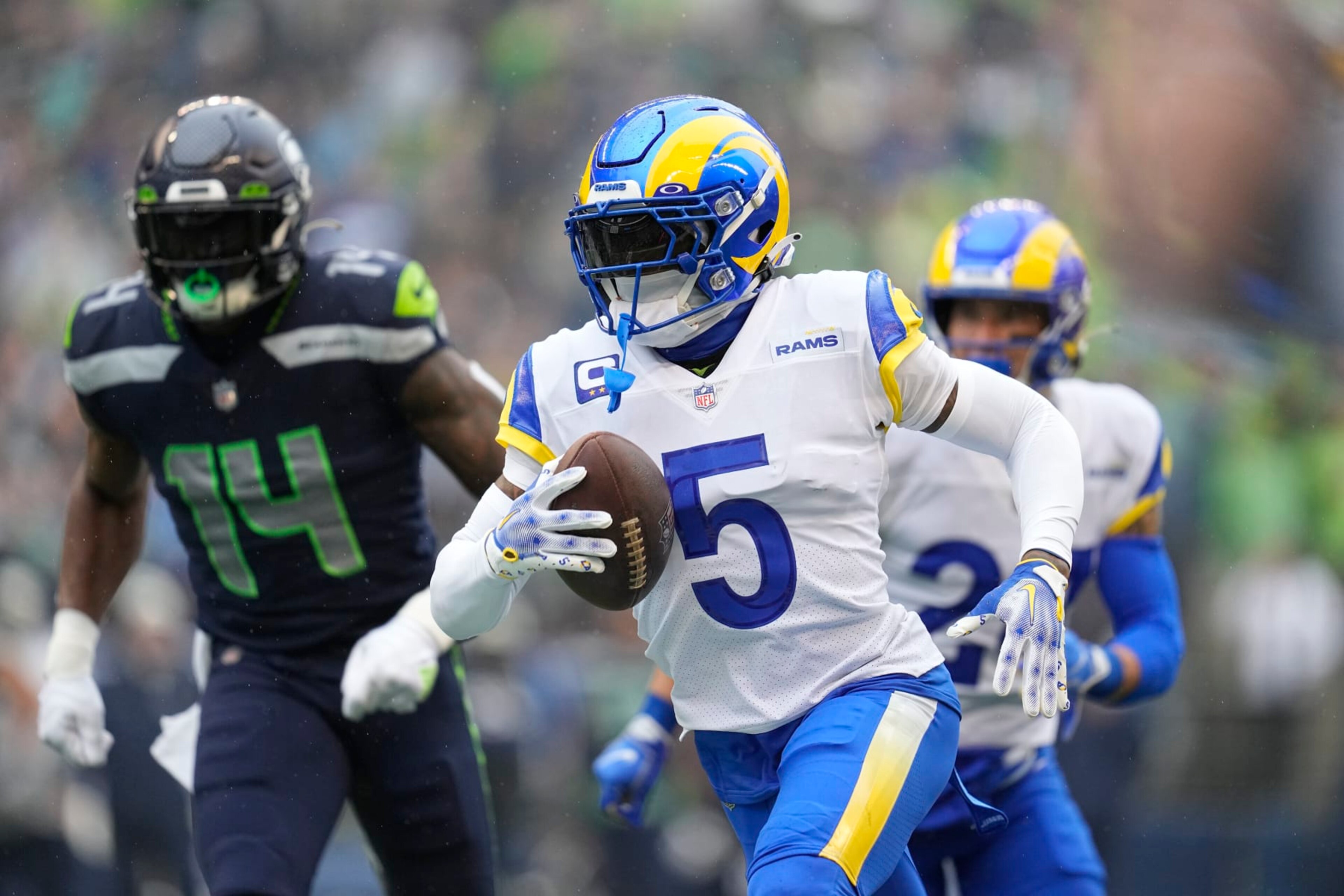 Los Angeles Rams cornerback Jalen Ramsey (5) runs with an intercepted pass past Seattle Seahawks wide receiver DK Metcalf (14) during the first half of an NFL football game Sunday, Jan. 8, 2023, in Seattle. (AP Photo/Abbie Parr)