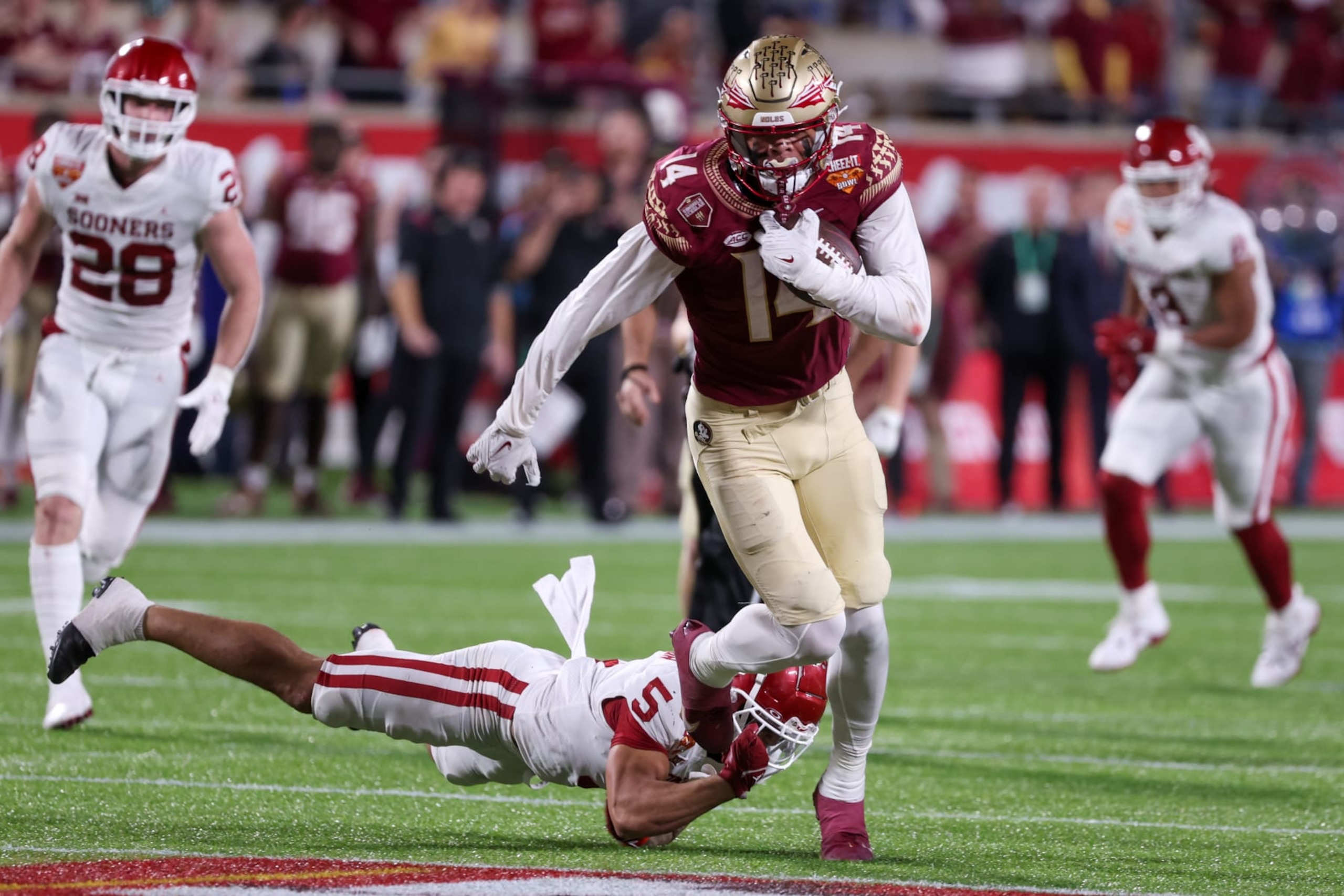 ORLANDO, FL - DECEMBER 29: Florida State Seminoles wide receiver Johnny Wilson (14) escapes a tackle from Oklahoma Sooners defensive back Billy Bowman (5) during the Cheez-It Bowl between Oklahoma and Florida State on December 29, 2022 at Camping World Stadium, in Orlando FL. (Photo by Joe Petro/Icon Sportswire via Getty Images) ORLANDO, FL - DECEMBER 29: Florida State Seminoles wide receiver Johnny Wilson (14) escapes a tackle from Oklahoma Sooners defensive back Billy Bowman (5) during the Cheez-It Bowl between Oklahoma and Florida State on December 29, 2022 at Camping World Stadium, in Orlando FL. (Photo by Joe Petro/Icon Sportswire via Getty Images)