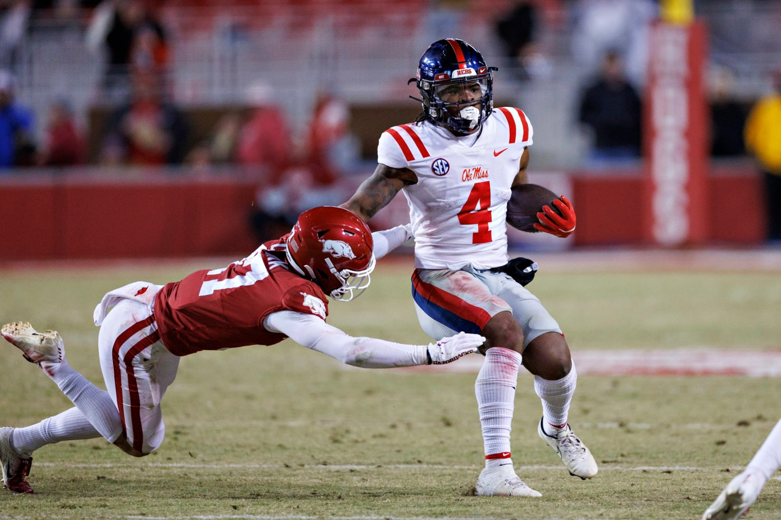FAYETTEVILLE, ARKANSAS - NOVEMBER 19: Quinshon Judkins #4 of the Mississippi Rebels runs the ball in the second half as Hudson Clark #17 of the Arkansas Razorbacks goes for the tackle at Donald W. Reynolds Razorback Stadium on November 19, 2022 in Fayetteville, Arkansas. The Razorbacks defeated the Rebels 42-27. (Photo by Wesley Hitt/Getty Images) FAYETTEVILLE, ARKANSAS - NOVEMBER 19: Quinshon Judkins #4 of the Mississippi Rebels runs the ball in the second half as Hudson Clark #17 of the Arkansas Razorbacks goes for the tackle at Donald W. Reynolds Razorback Stadium on November 19, 2022 in Fayetteville, Arkansas. The Razorbacks defeated the Rebels 42-27. (Photo by Wesley Hitt/Getty Images)