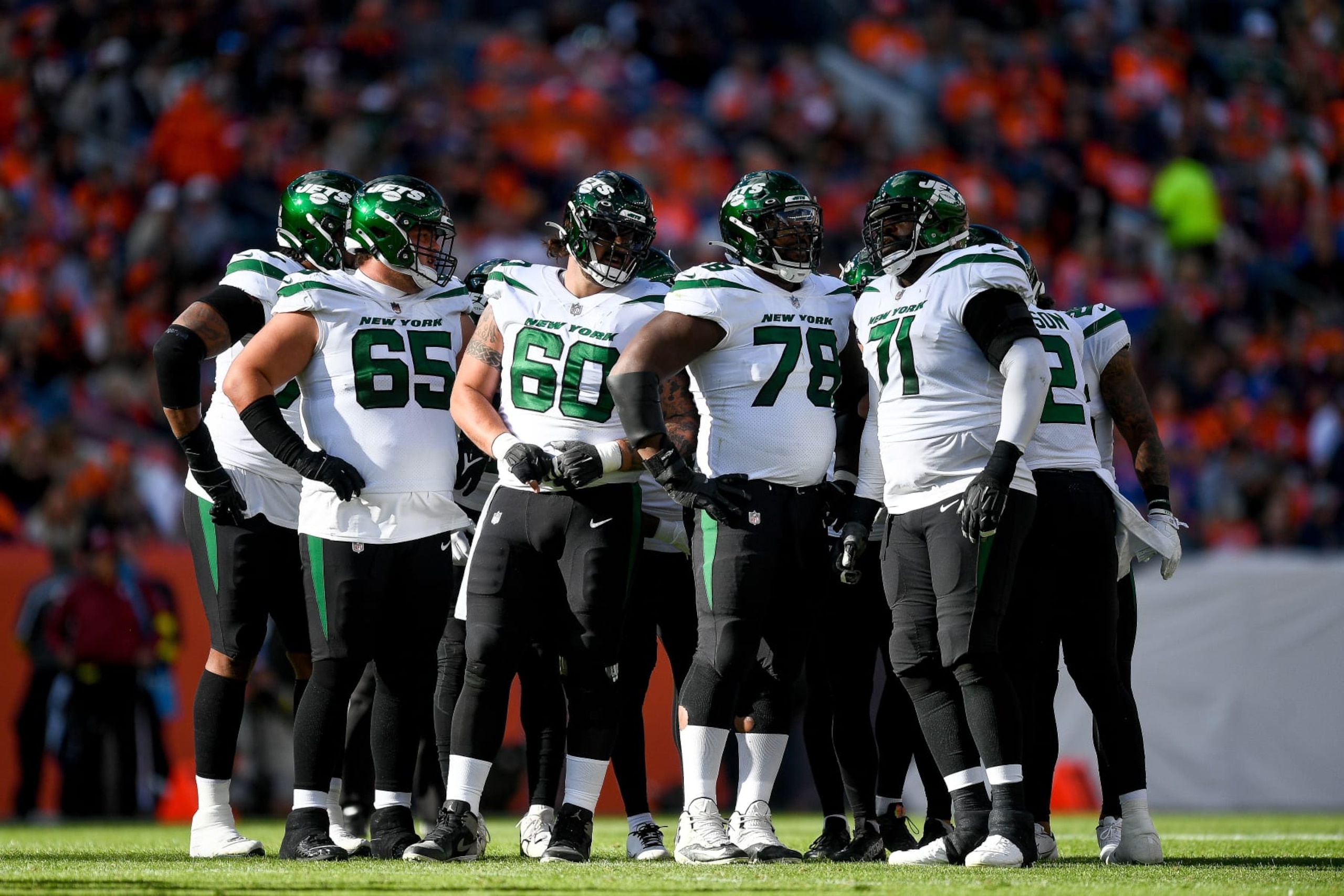 DENVER, COLORADO - OCTOBER 23: New York Jets players, including guard Nate Herbig #65, center Connor McGovern #60, guard Laken Tomlinson #78, and offensive tackle Duane Brown #71 huddle before a play against the Denver Broncos at Empower Field at Mile High on October 23, 2022 in Denver, Colorado. (Photo by Dustin Bradford/Getty Images) DENVER, COLORADO - OCTOBER 23: New York Jets players, including guard Nate Herbig #65, center Connor McGovern #60, guard Laken Tomlinson #78, and offensive tackle Duane Brown #71 huddle before a play against the Denver Broncos at Empower Field at Mile High on October 23, 2022 in Denver, Colorado. (Photo by Dustin Bradford/Getty Images)