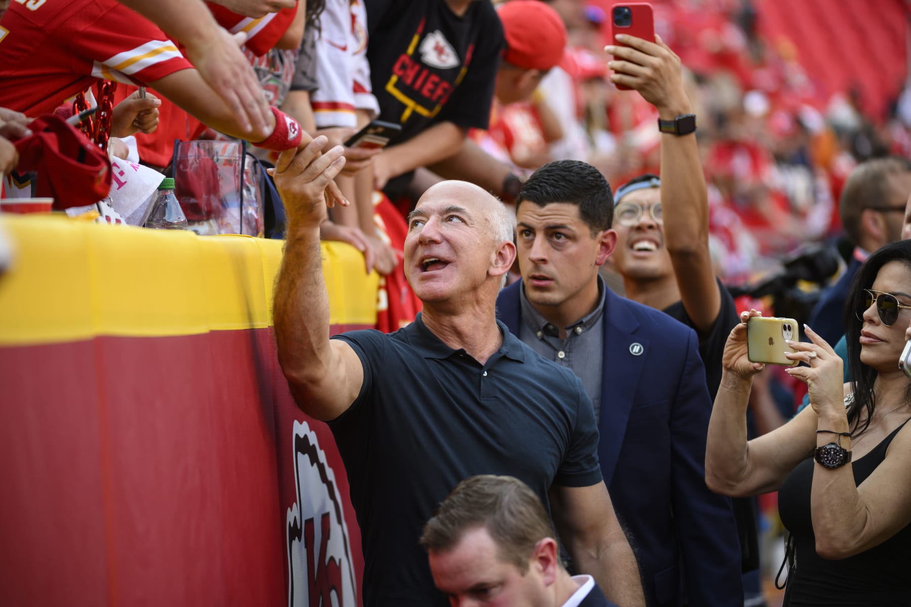 Jeff Bezos, founder of Amazon, visits with fans during pre-game warmups before an NFL football game between the Kansas City Chiefs and the Los Angeles Chargers, Thursday, Sept. 15, 2022 in Kansas City, Mo. (AP Photo/Reed Hoffmann)