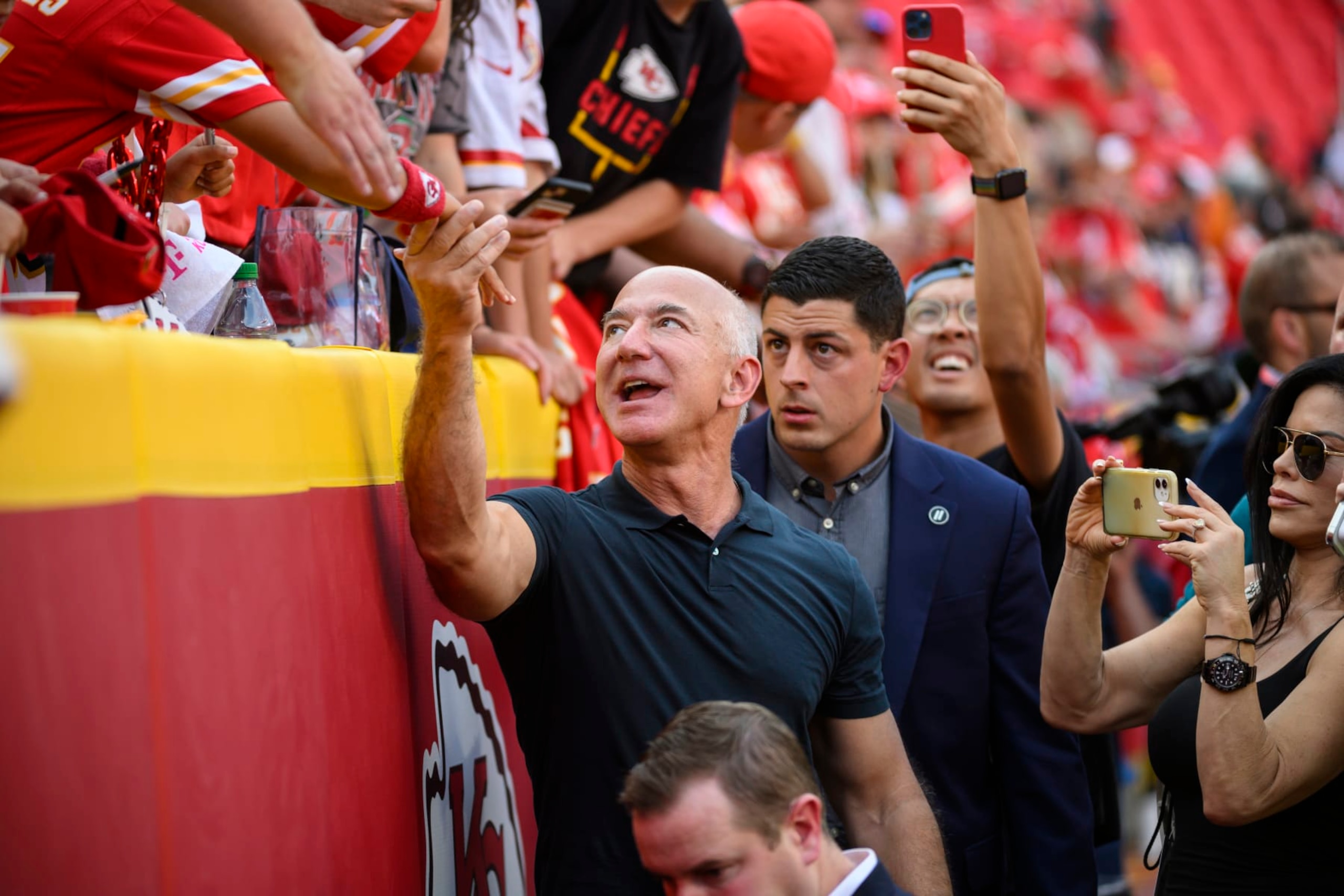 Jeff Bezos, founder of Amazon, visits with fans during pre-game warmups before an NFL football game between the Kansas City Chiefs and the Los Angeles Chargers, Thursday, Sept. 15, 2022 in Kansas City, Mo. (AP Photo/Reed Hoffmann)