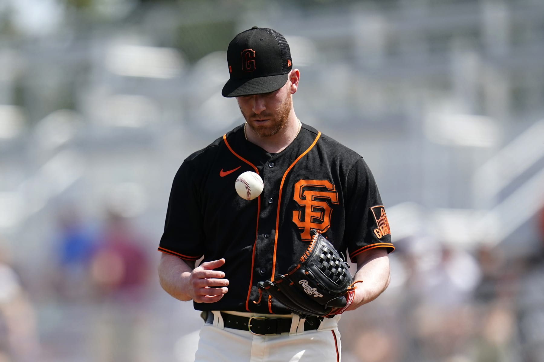 San Francisco Giants starting pitcher Anthony DeSclafani flips the ball in the air as he pauses on the mound during the second inning of the team's spring training baseball game against the Cleveland Guardians on Friday, March 25, 2022, in Scottsdale, Ariz. (AP Photo/Ross D. Franklin)
