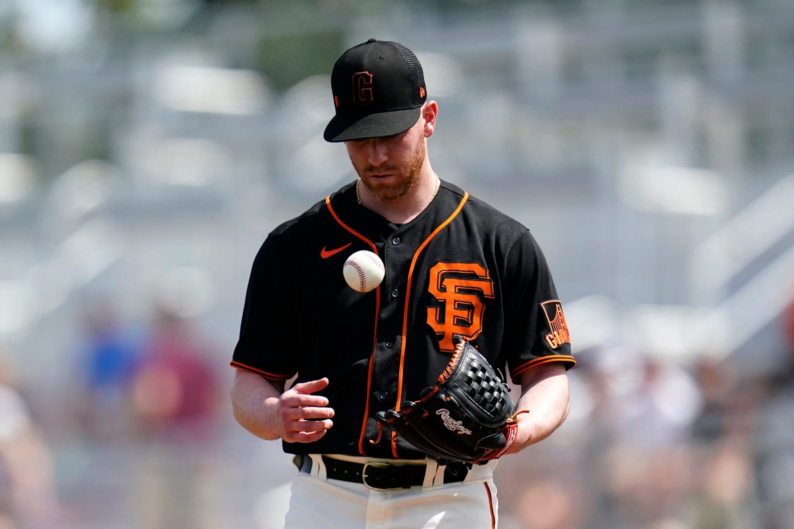 San Francisco Giants starting pitcher Anthony DeSclafani flips the ball in the air as he pauses on the mound during the second inning of the team's spring training baseball game against the Cleveland Guardians on Friday, March 25, 2022, in Scottsdale, Ariz. (AP Photo/Ross D. Franklin)