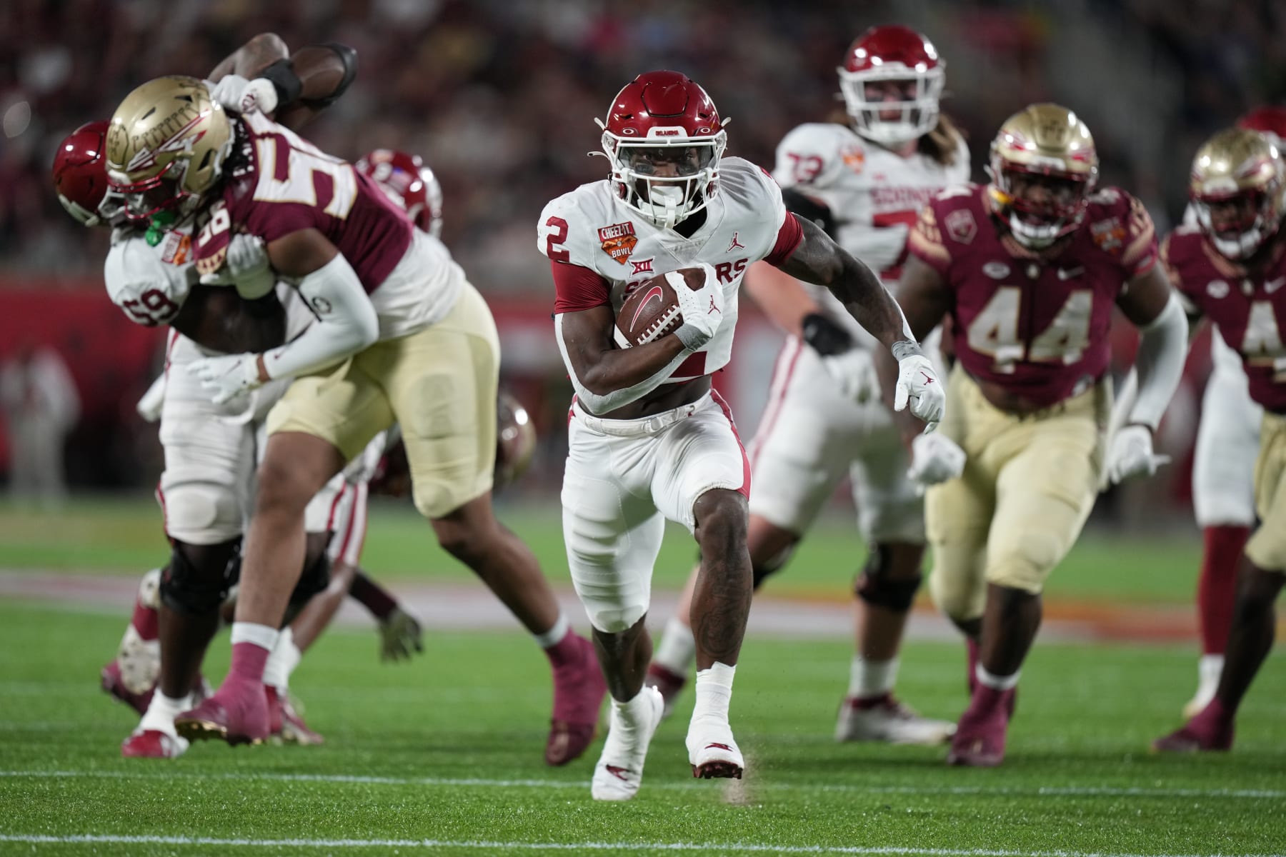 ORLANDO, FL - DECEMBER 29: Oklahoma Sooners running back Jovantae Barnes (2) breaks through the line to run for a big gain in the first half during the Cheez-It Bowl between between the Oklahoma Sooners and the Florida State Seminoles on Thursday, December 29, 2022 at Camping World Stadium, Orlando, Fla. (Photo by Peter Joneleit/Icon Sportswire via Getty Images)