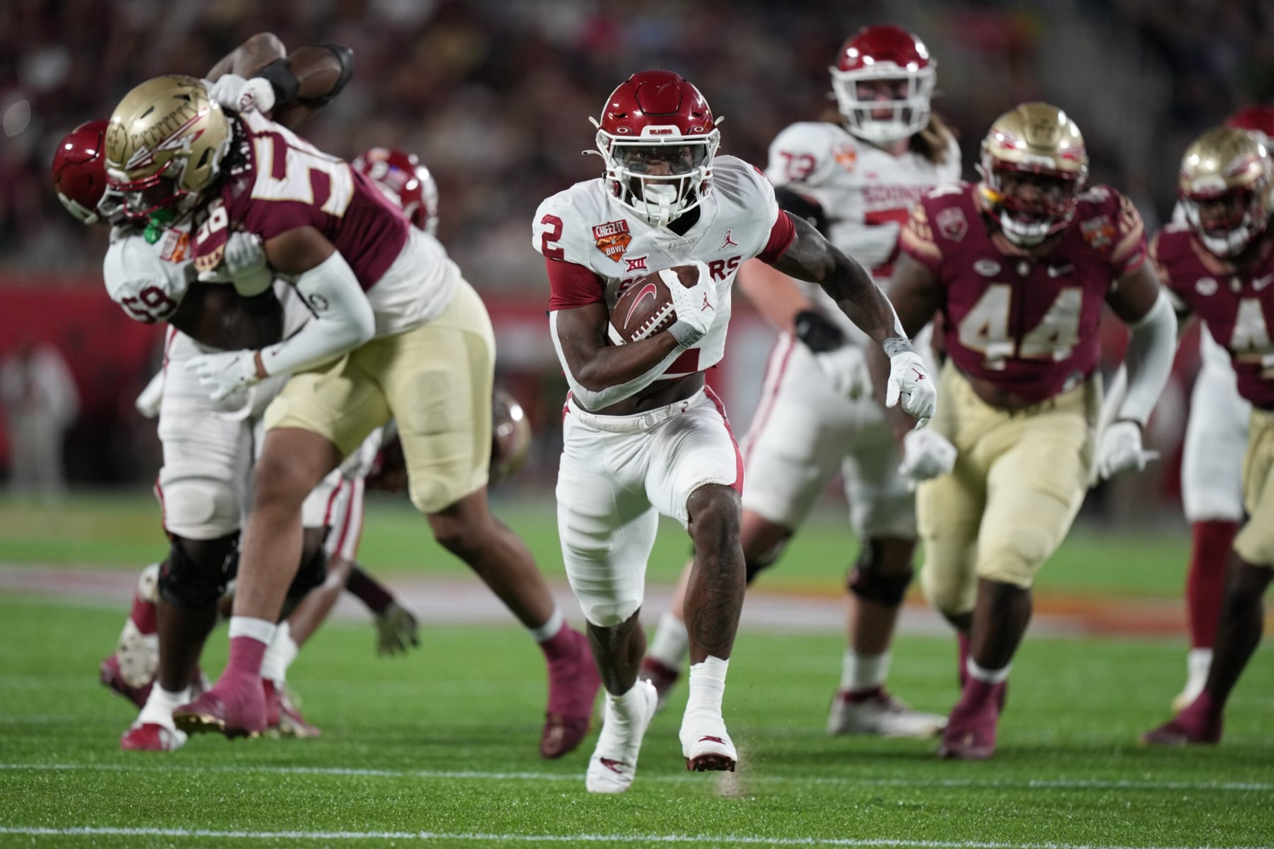 ORLANDO, FL - DECEMBER 29: Oklahoma Sooners running back Jovantae Barnes (2) breaks through the line to run for a big gain in the first half during the Cheez-It Bowl between between the Oklahoma Sooners and the Florida State Seminoles on Thursday, December 29, 2022 at Camping World Stadium, Orlando, Fla. (Photo by Peter Joneleit/Icon Sportswire via Getty Images)