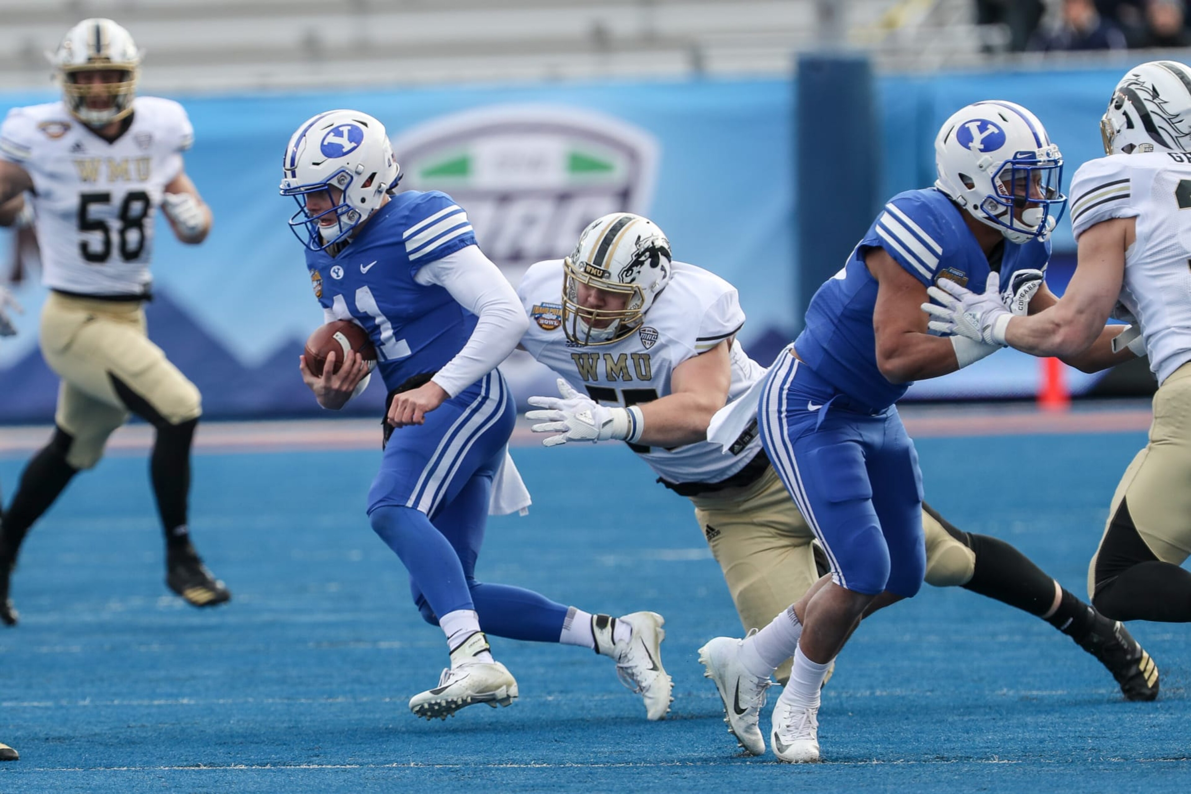 BOISE, ID - DECEMBER 21: Quarterback Zach Wilson #11 of the BYU Cougars slips away from a sack attempt by defensive lineman Braden Fiske #55 of the Western Michigan Broncos during first half action at the Famous Idaho Potato Bowl on December 21, 2018 at Albertsons Stadium in Boise, Idaho. (Photo by Loren Orr/Getty Images)