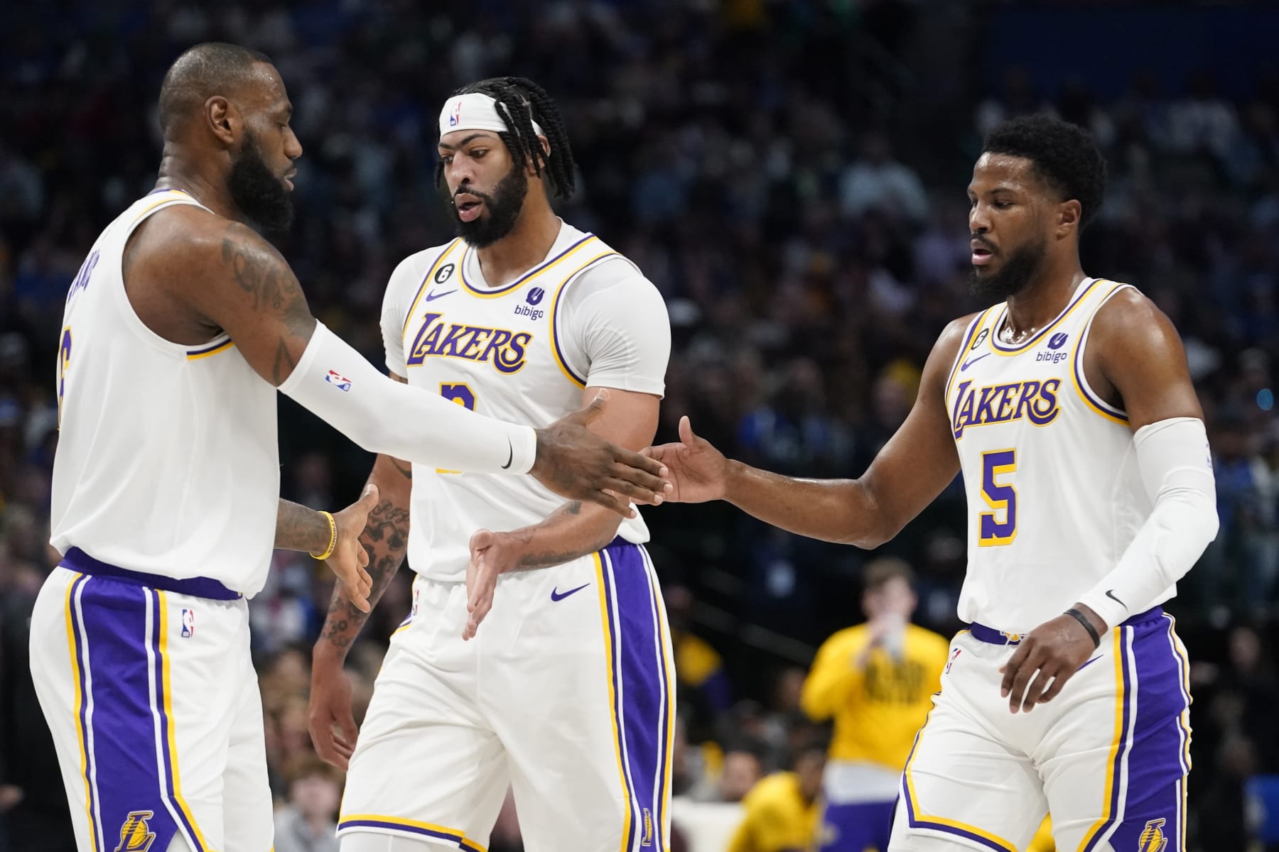 Los Angeles Lakers guard Malik Beasley (5) and forward Anthony Davis (3) get a congrats from teammate forward LeBron James (6) during the first quarter of an NBA basketball game against the Dallas Mavericks in Dallas, Sunday, Feb. 26, 2023. (AP Photo/LM Otero)