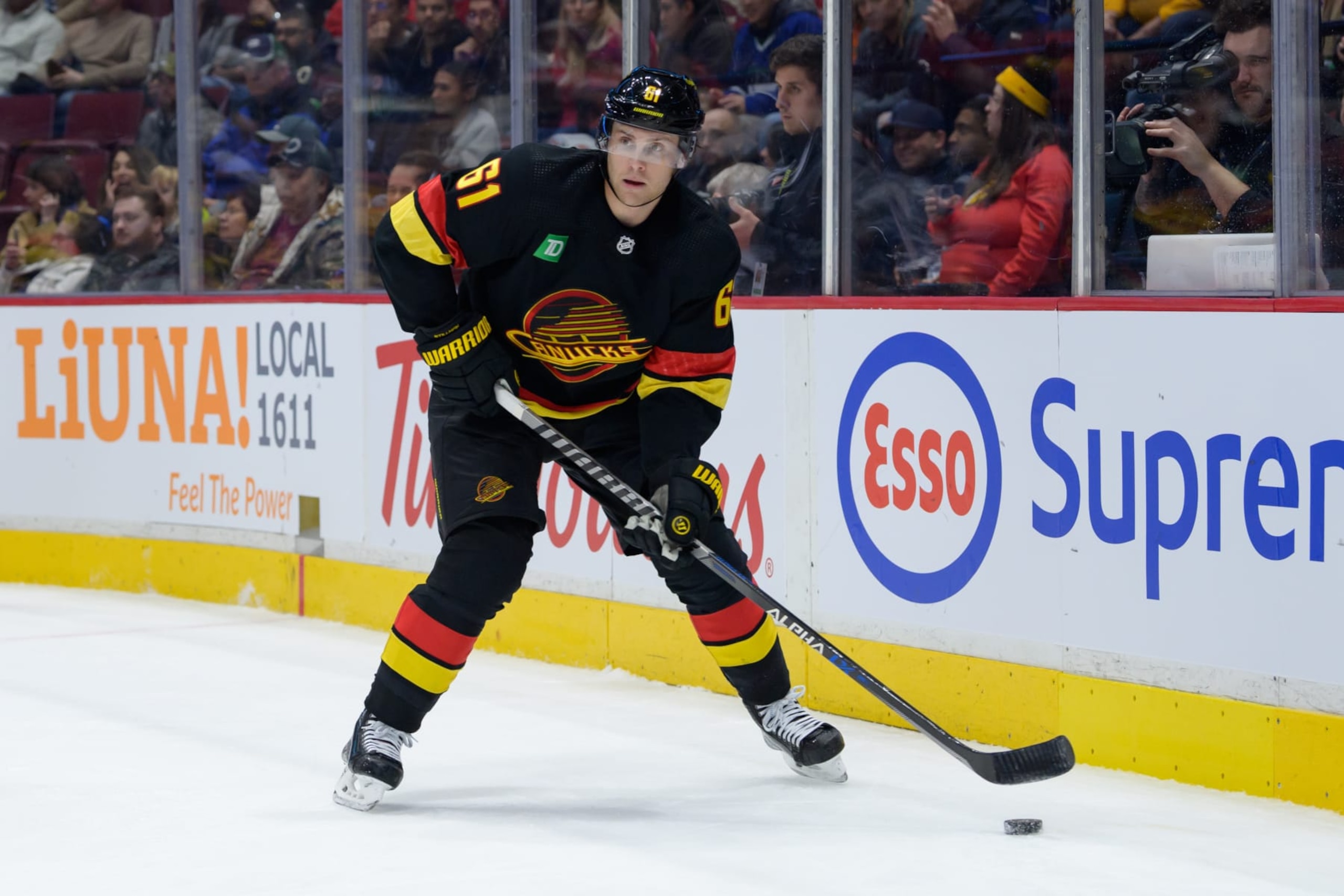 VANCOUVER, CANADA - FEBRUARY 13: Riley Stillman #61 of the Vancouver Canucks skates with the puck during the first period of their NHL game against the Detroit Red Wings at Rogers Arena on February 13, 2023 in Vancouver, British Columbia, Canada. (Photo by Derek Cain/Getty Images)