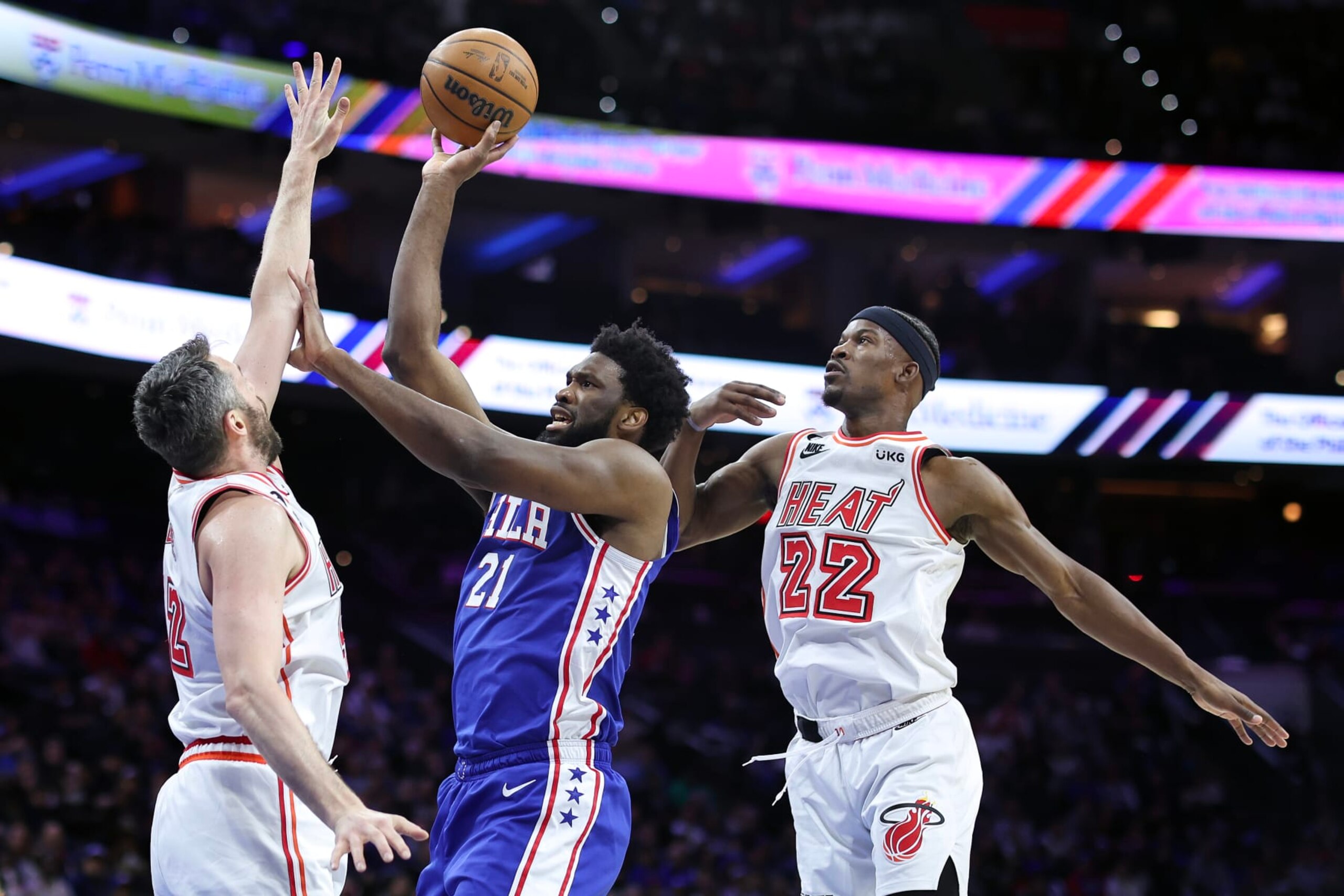 PHILADELPHIA, PENNSYLVANIA - FEBRUARY 27: Joel Embiid #21 of the Philadelphia 76ers shoots between Kevin Love #42 and Jimmy Butler #22 of the Miami Heat during the first quarter at Wells Fargo Center on February 27, 2023 in Philadelphia, Pennsylvania. NOTE TO USER: User expressly acknowledges and agrees that, by downloading and or using this photograph, User is consenting to the terms and conditions of the Getty Images License Agreement. (Photo by Tim Nwachukwu/Getty Images)