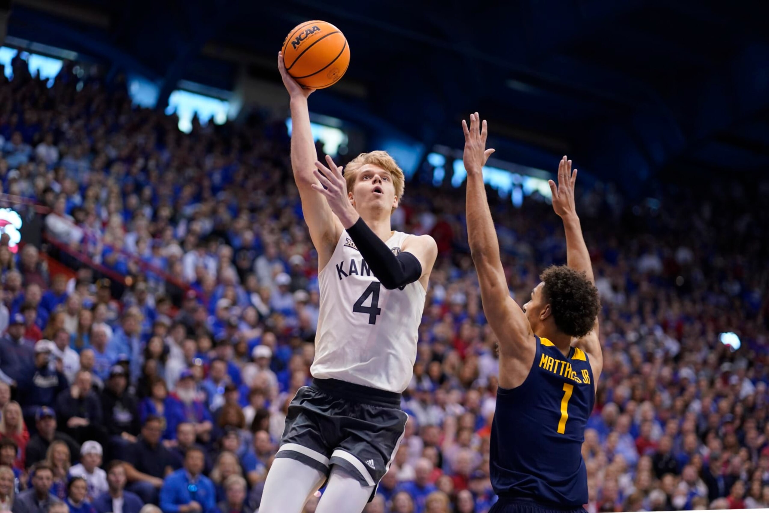 LAWRENCE, KANSAS - FEBRUARY 25: Gradey Dick #4 of the Kansas Jayhawks lays the ball up against Emmitt Matthews Jr. #1 of the West Virginia Mountaineers in the first half at Allen Fieldhouse on February 25, 2023 in Lawrence, Kansas. (Photo by Ed Zurga/Getty Images)
