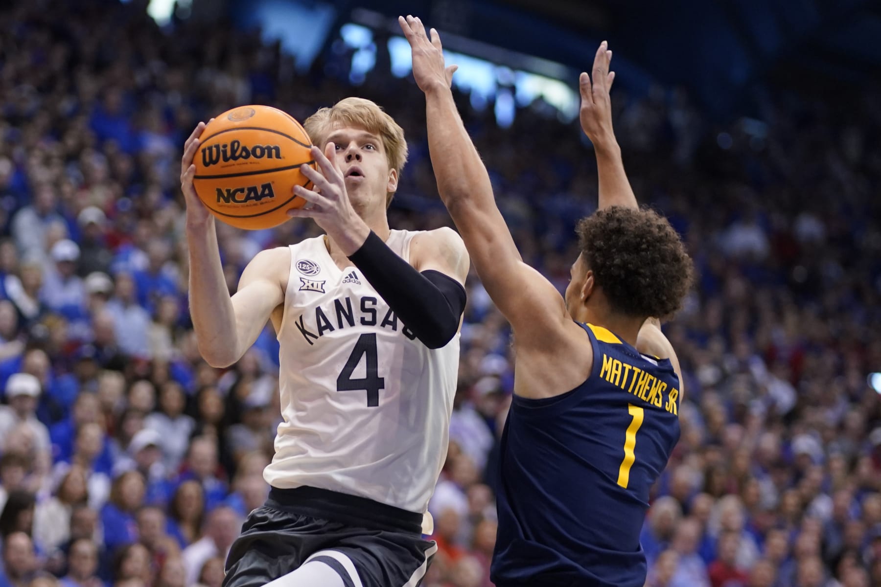 LAWRENCE, KANSAS - FEBRUARY 25: Gradey Dick #4 of the Kansas Jayhawks lays the ball up against Emmitt Matthews Jr. #1 of the West Virginia Mountaineers in the first half of the game at Allen Fieldhouse on February 25, 2023 in Lawrence, Kansas. (Photo by Ed Zurga/Getty Images)