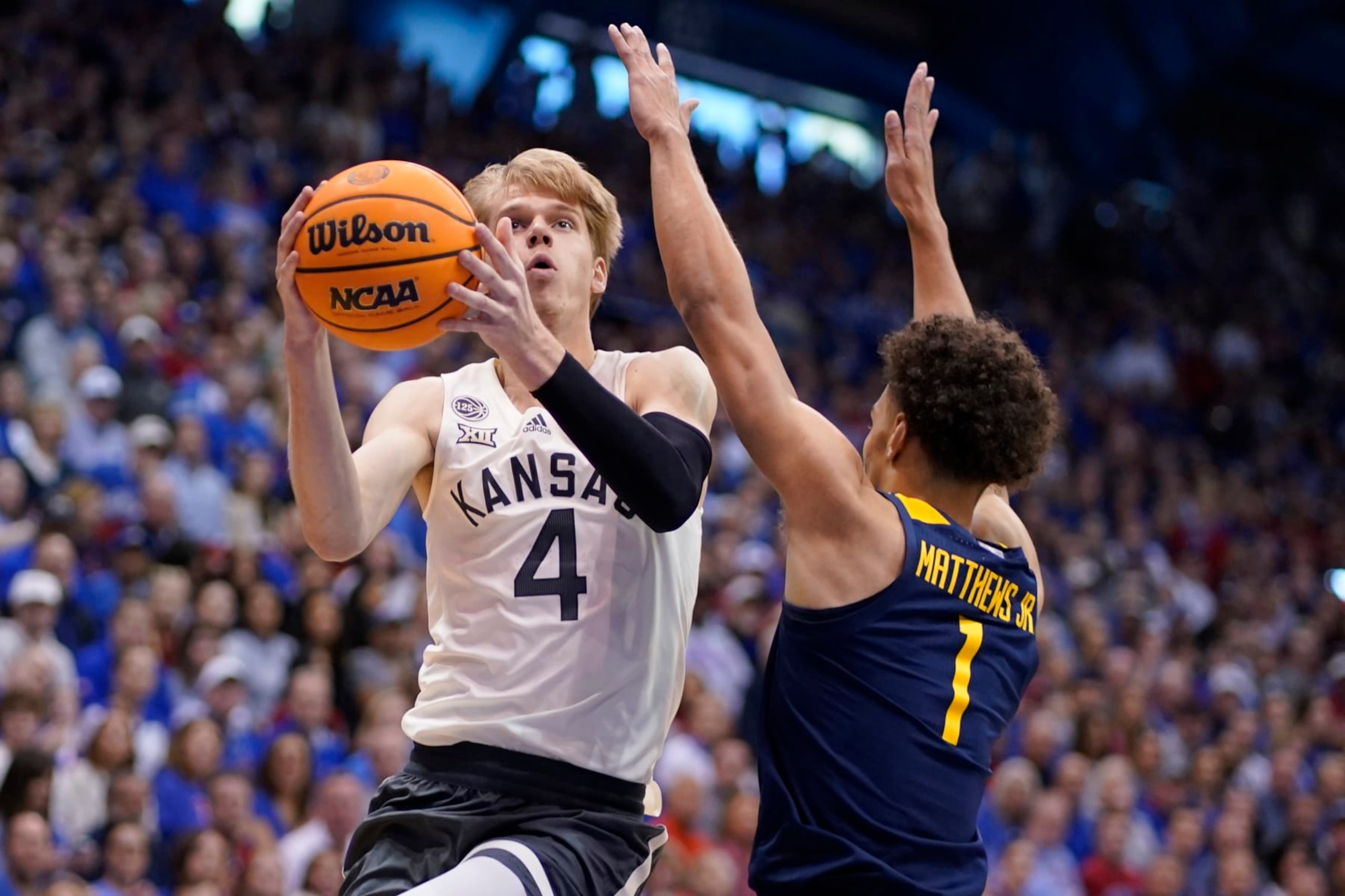 LAWRENCE, KANSAS - FEBRUARY 25: Gradey Dick #4 of the Kansas Jayhawks lays the ball up against Emmitt Matthews Jr. #1 of the West Virginia Mountaineers in the first half of the game at Allen Fieldhouse on February 25, 2023 in Lawrence, Kansas. (Photo by Ed Zurga/Getty Images)