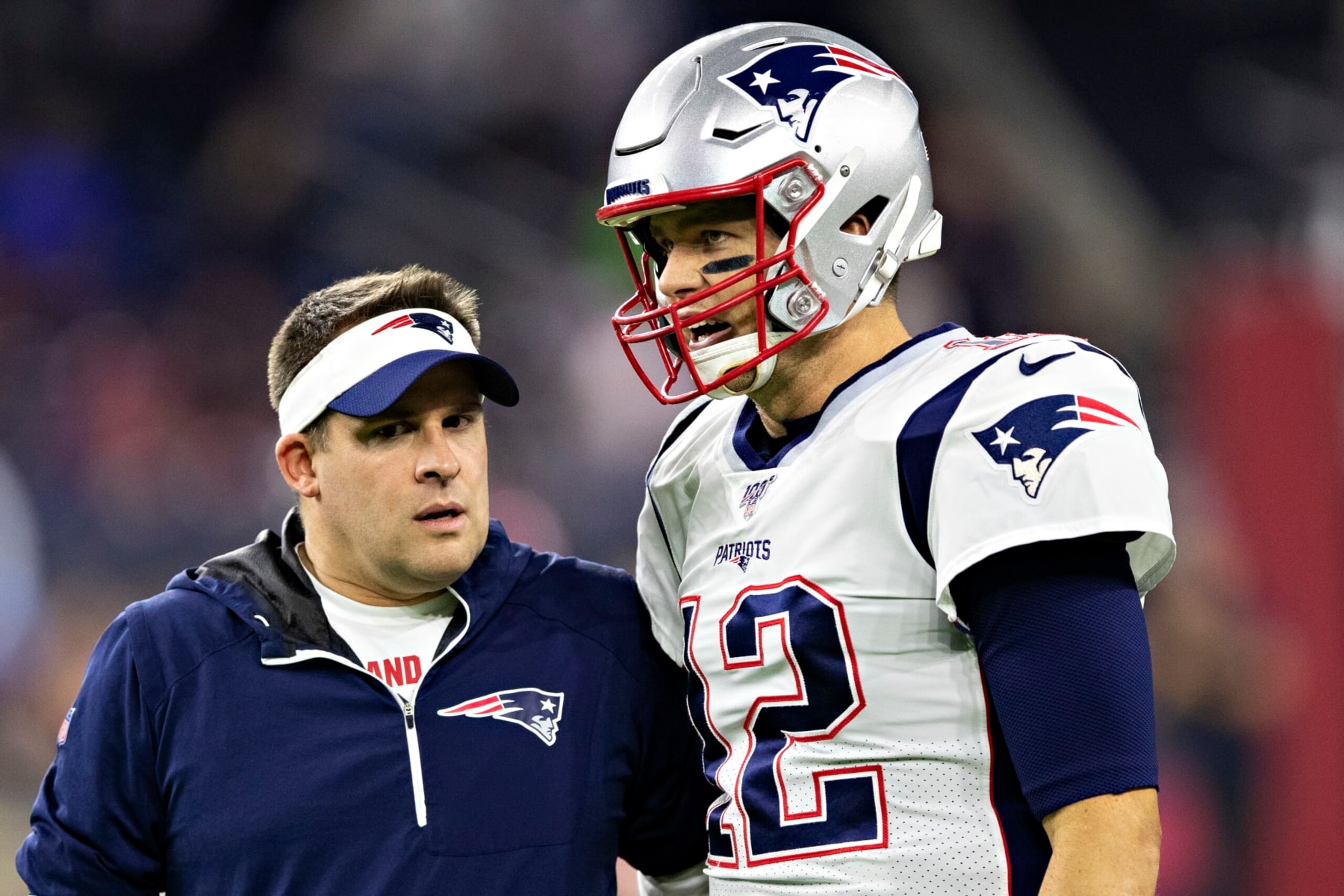 HOUSTON, TX - DECEMBER 1:  Offensive Coordinator Josh McDaniels talks with Tom Brady #12 of the New England Patriots before a game against the Houston Texans at NRG Stadium on December 1, 2019 in Houston, Texas.  The Texans defeated the Patriots 28-22.  (Photo by Wesley Hitt/Getty Images)