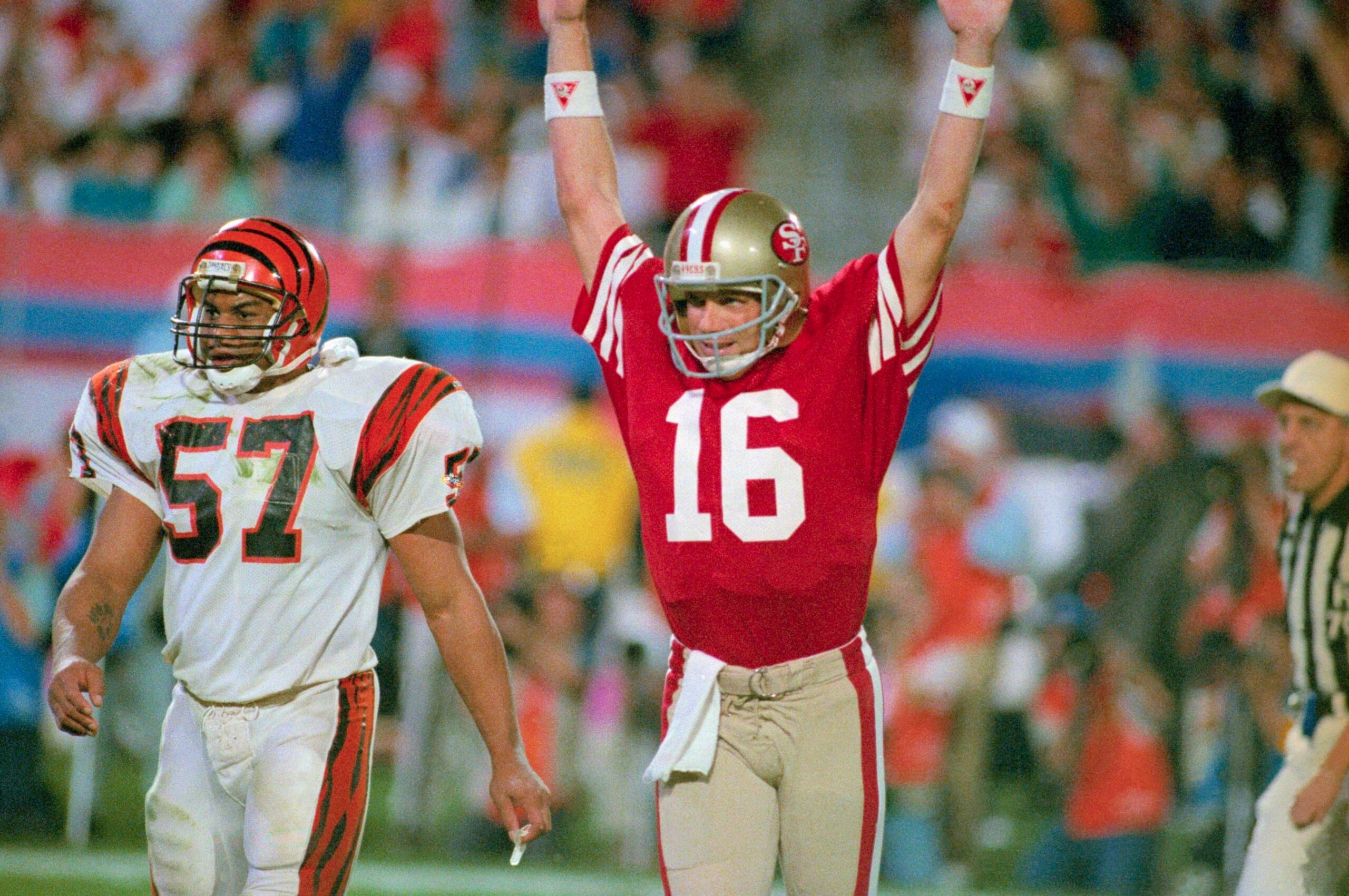(Original Caption) 49ers quarterback Joe Montana raises his arm in celebration after throwing a touchdown pass to Jerry Rice in the fourth quarter. Bengal Sam Kennedy looks on. (Original Caption) 49ers quarterback Joe Montana raises his arm in celebration after throwing a touchdown pass to Jerry Rice in the fourth quarter. Bengal Sam Kennedy looks on.