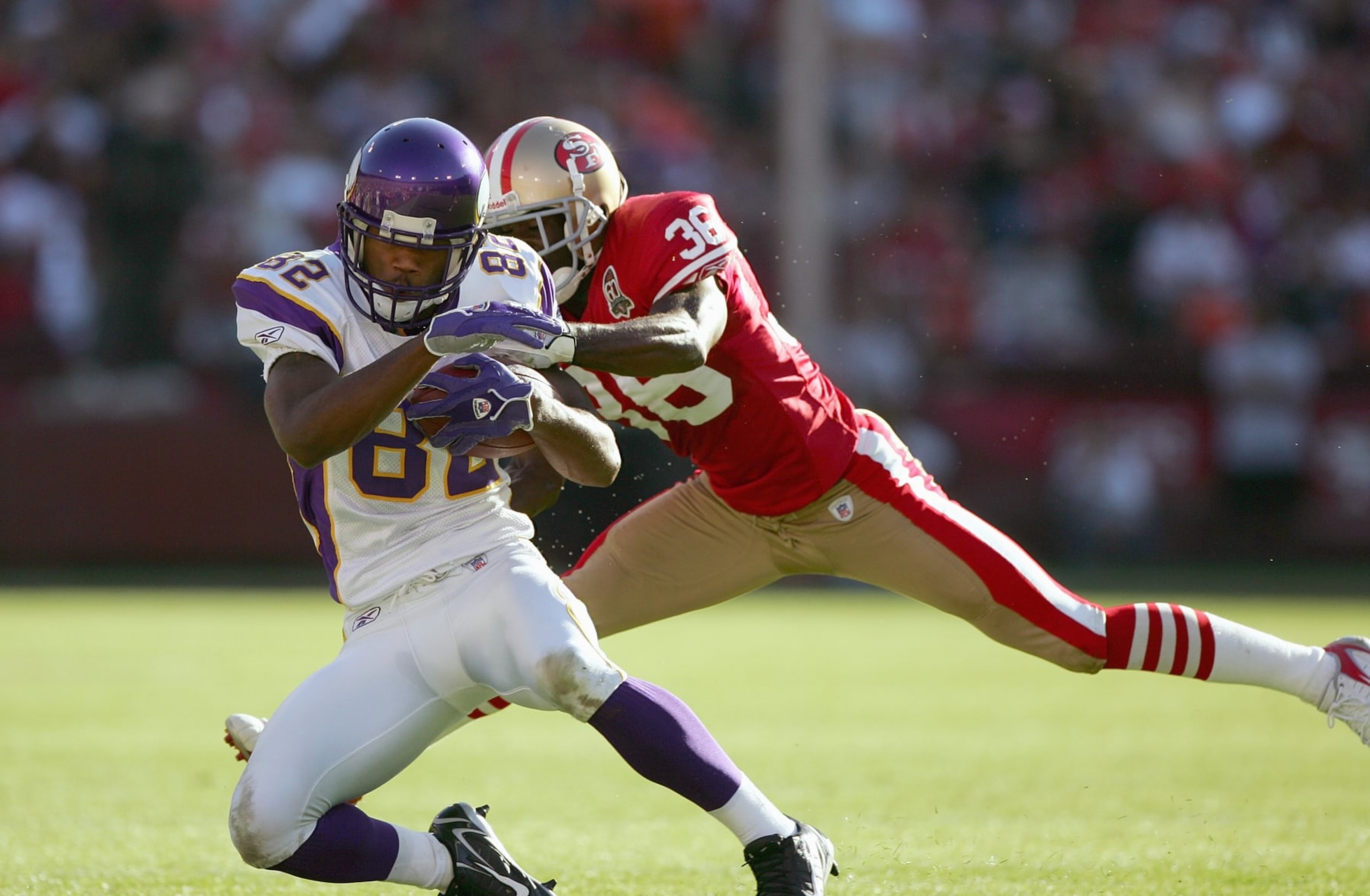 SAN FRANCISCO - NOVEMBER 5:  Troy Williamson #82 of the Minnesota Vikings grips the ball as he is tackled by Shawntae Spencer #36 of the San Francisco 49ers at Monster Park on November 5, 2006 in San Francisco, California. (Photo by Jed Jacobsohn/Getty Images)