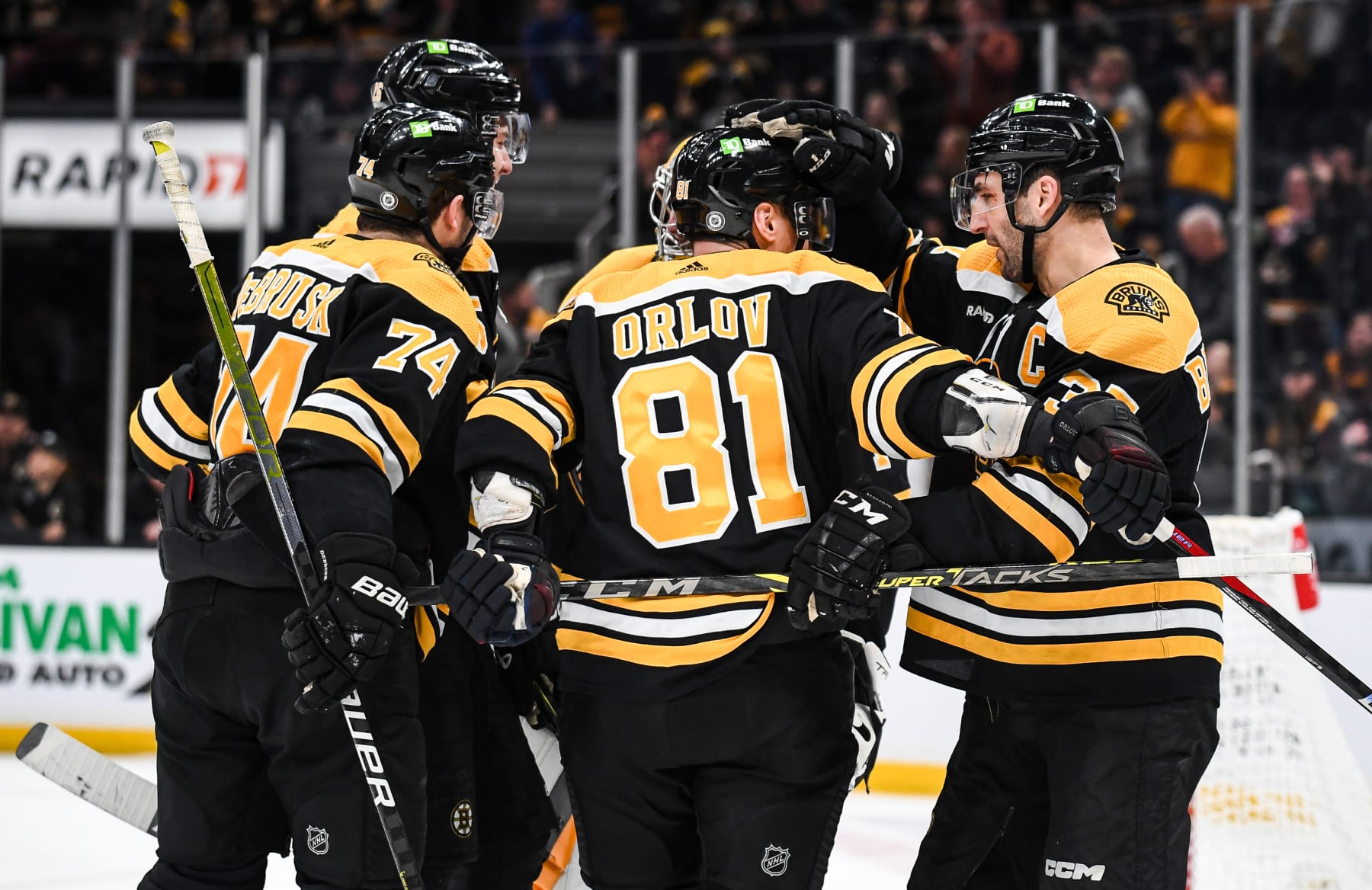 BOSTON, MASSACHUSETTS - MARCH 02: Patrice Bergeron #37 of the Boston Bruins celebrates his third-period goal with Dmitry Orlov #81 and Jake DeBrusk #74 against the Buffalo Sabres at TD Garden on March 02, 2023 in Boston, Massachusetts. (Photo by China Wong/NHLI via Getty Images)