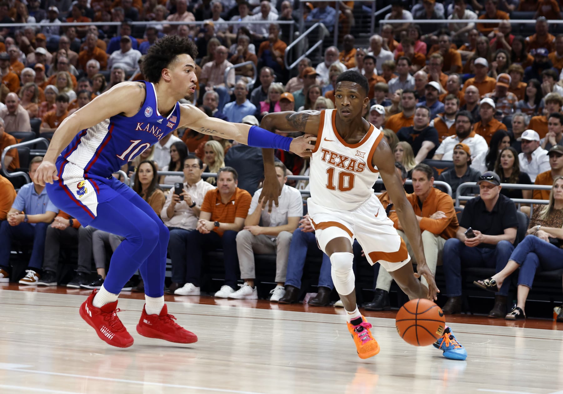 AUSTIN, TX - MARCH 04: Texas Longhorns guard SirJabari Rice (10) dribbles past Kansas Jayhawks forward Jalen Wilson (10) during the game at the Moody Center in Austin, TX on March 04, 2023. (Photo by Adam Davis/Icon Sportswire via Getty Images)