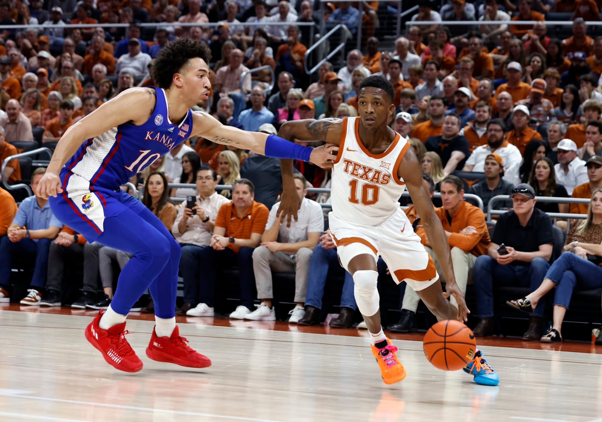AUSTIN, TX - MARCH 04: Texas Longhorns guard SirJabari Rice (10) dribbles past Kansas Jayhawks forward Jalen Wilson (10) during the game at the Moody Center in Austin, TX on March 04, 2023. (Photo by Adam Davis/Icon Sportswire via Getty Images)