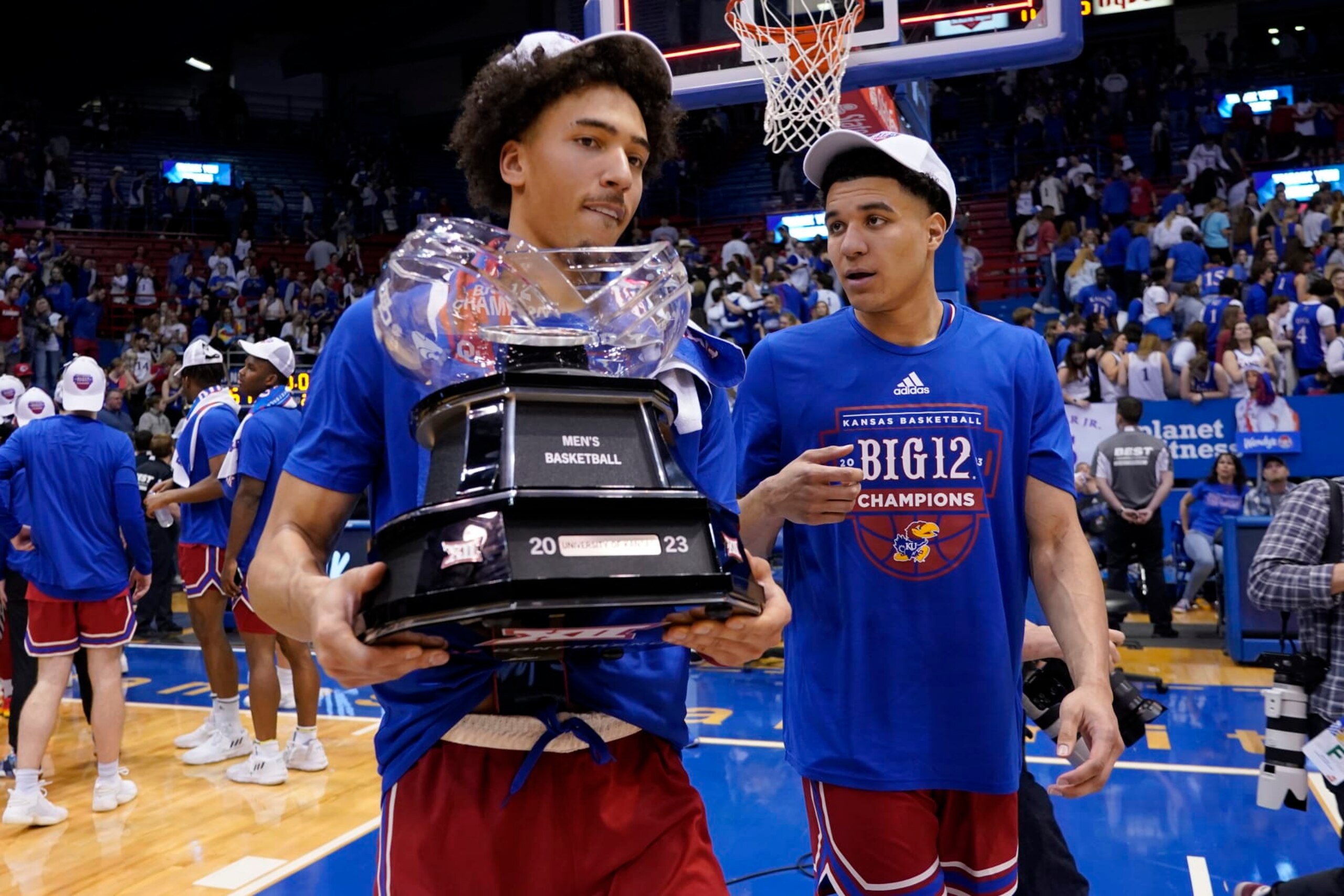 LAWRENCE, KANSAS - FEBRUARY 28: Jalen Wilson (L) #10 carries the Big 12 conference trophy with teammate Kevin McCullar Jr. #15 of the Kansas Jayhawks after their 67-63 win over Texas Tech Red Raiders at Allen Fieldhouse on February 28, 2023 in Lawrence, Kansas. (Photo by Ed Zurga/Getty Images)