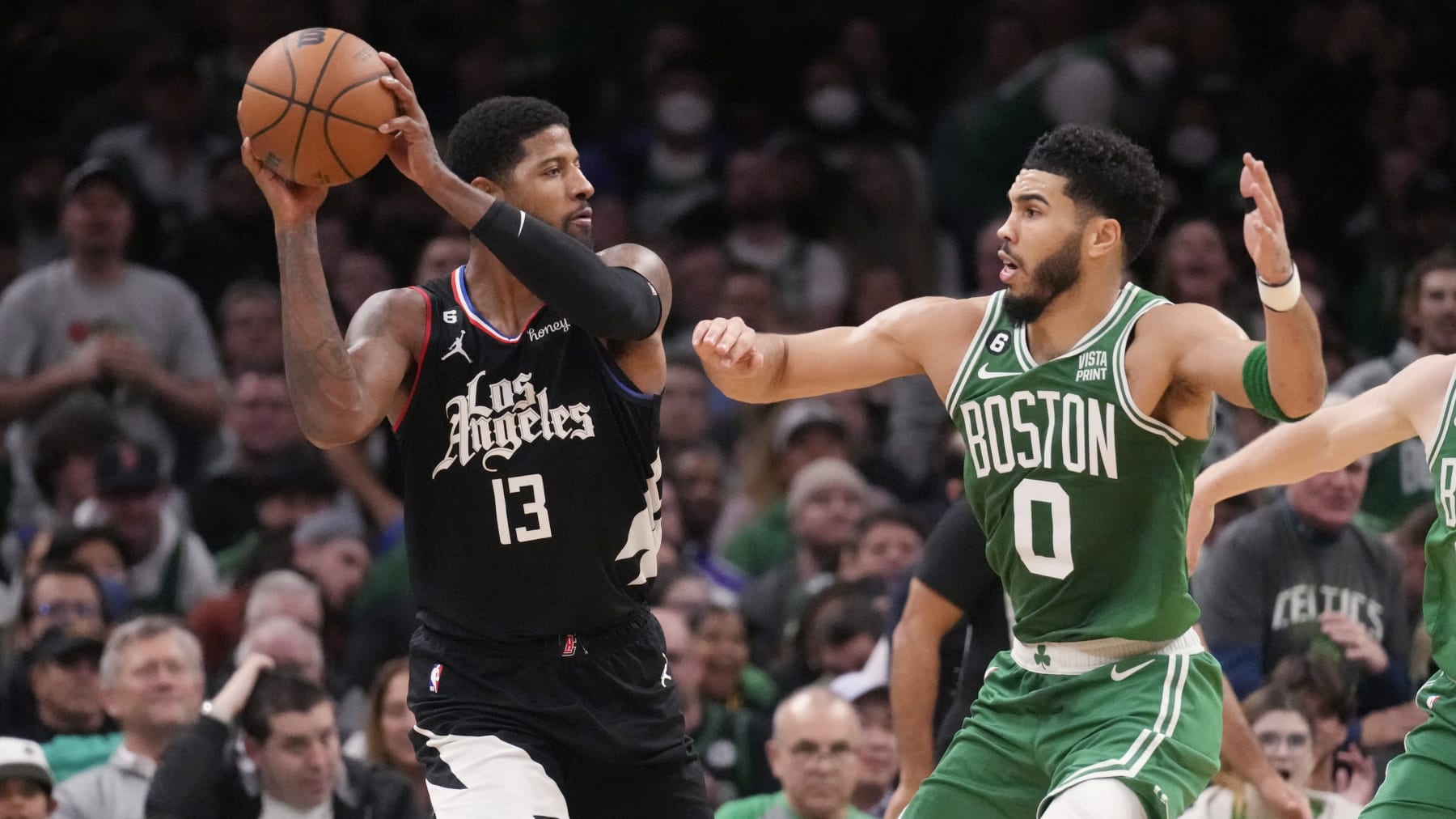 LA Clippers guard Paul George (13) looks to pass against Boston Celtics forward Jayson Tatum (0) during an NBA basketball game, Thursday, Dec. 29, 2022, in Boston. (AP Photo/Charles Krupa)