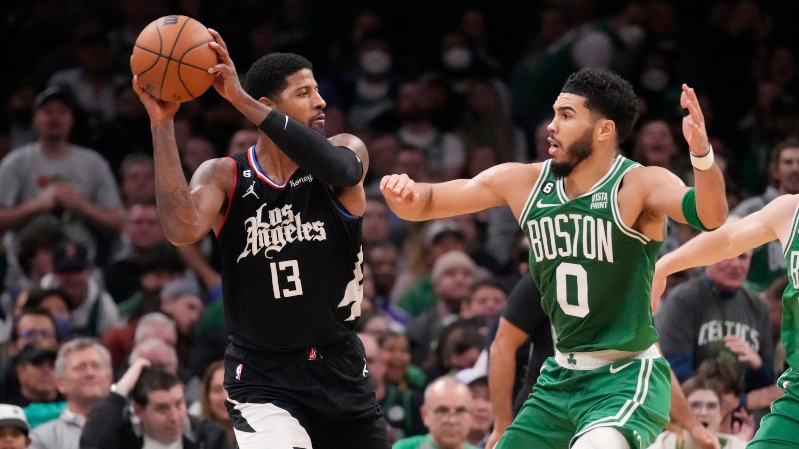 LA Clippers guard Paul George (13) looks to pass against Boston Celtics forward Jayson Tatum (0) during an NBA basketball game, Thursday, Dec. 29, 2022, in Boston. (AP Photo/Charles Krupa)