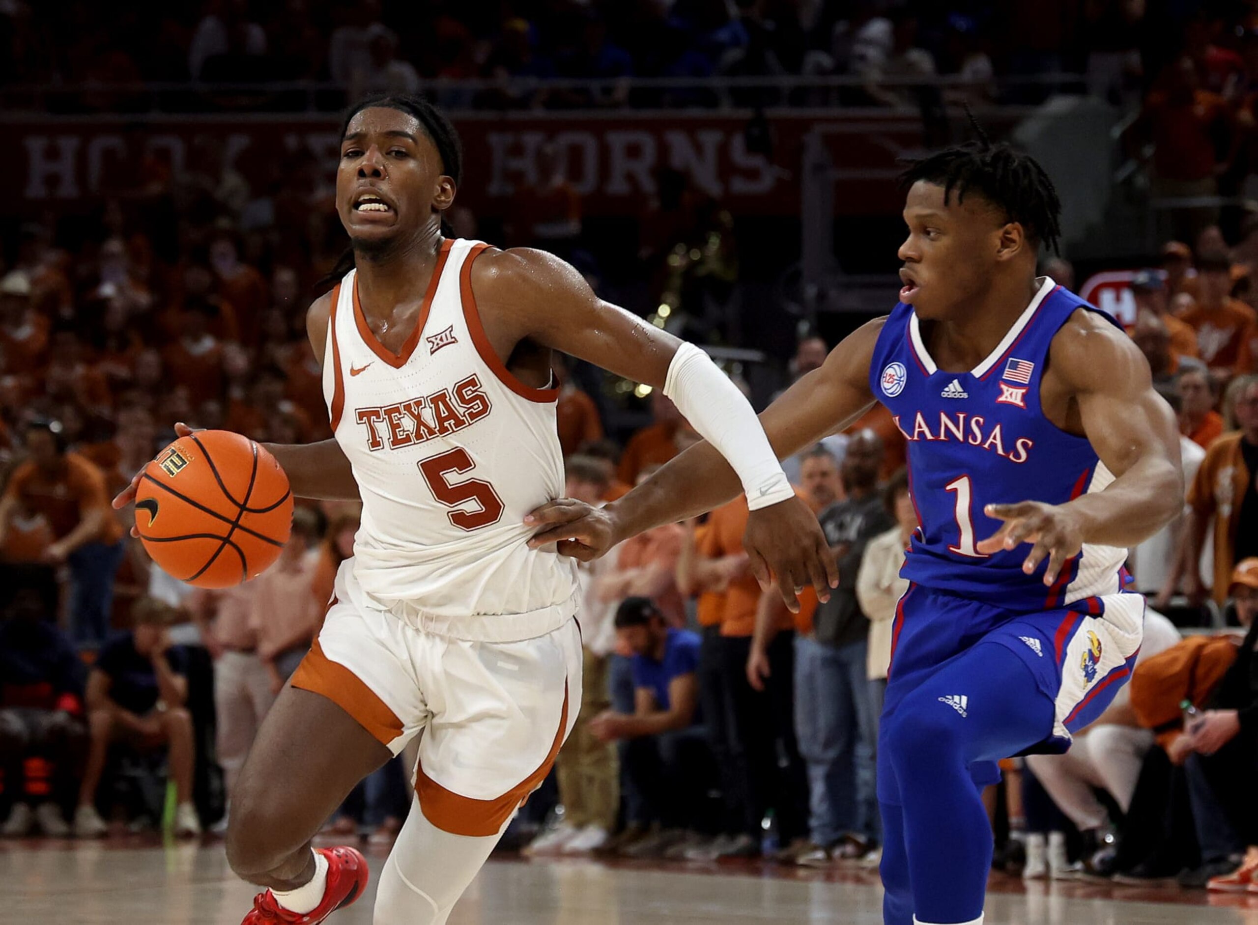 AUSTIN, TEXAS - MARCH 04: Marcus Carr #5 of the Texas Longhorns drives around Joseph Yesufu #1 of the Kansas Jayhawks in the second half at Moody Center on March 04, 2023 in Austin, Texas. (Photo by Chris Covatta/Getty Images)