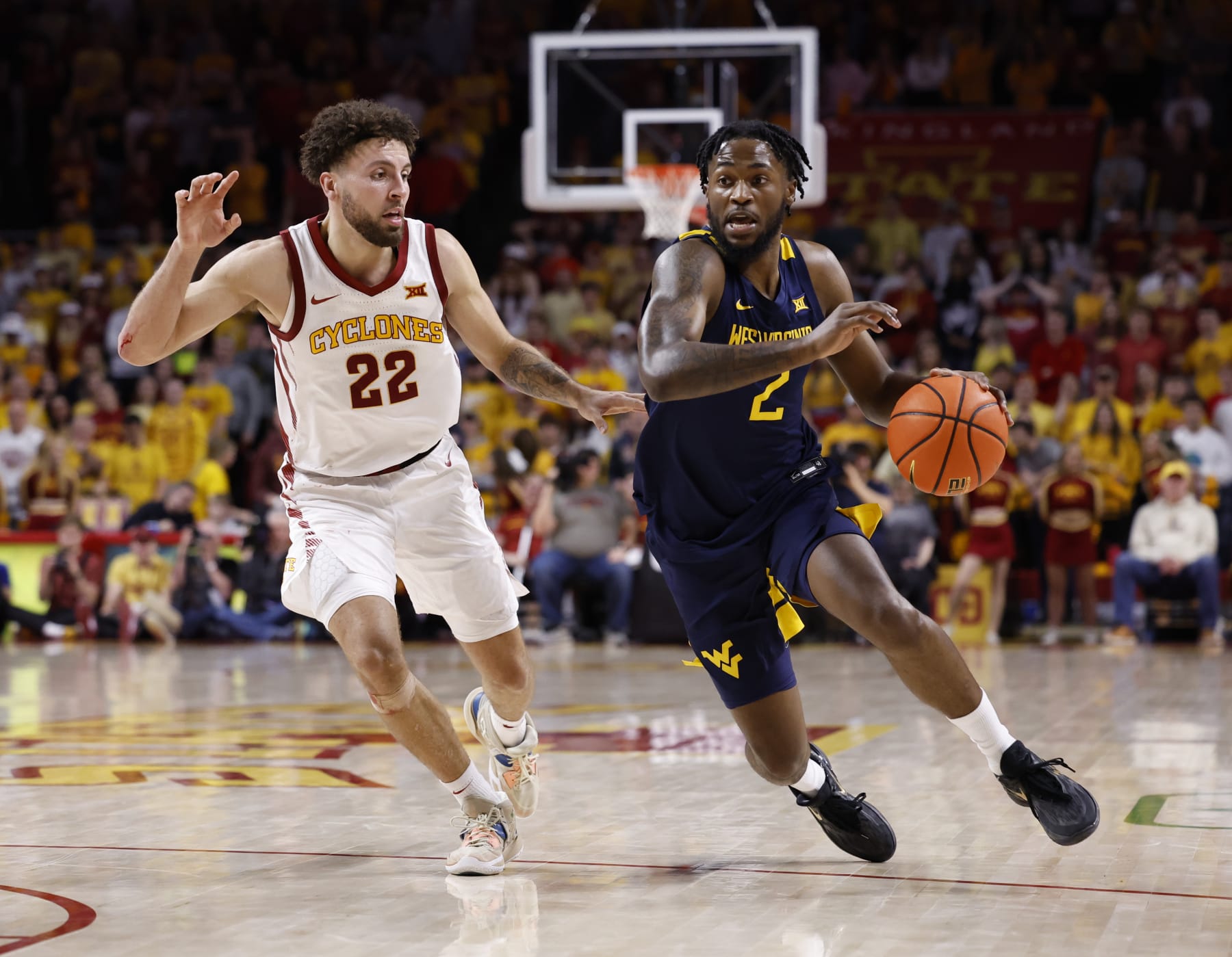 AMES, IA - FEBRUARY 27:  Kobe Johnson #2 of the West Virginia Mountaineers drives the ball as Gabe Kalscheur #22 of the Iowa State Cyclones defends in the second half of play at Hilton Coliseum on February 27, 2023 in Ames, Iowa. The West Virginia Mountaineers won 72-69 over the Iowa State Cyclones. (Photo by David K Purdy/Getty Images)