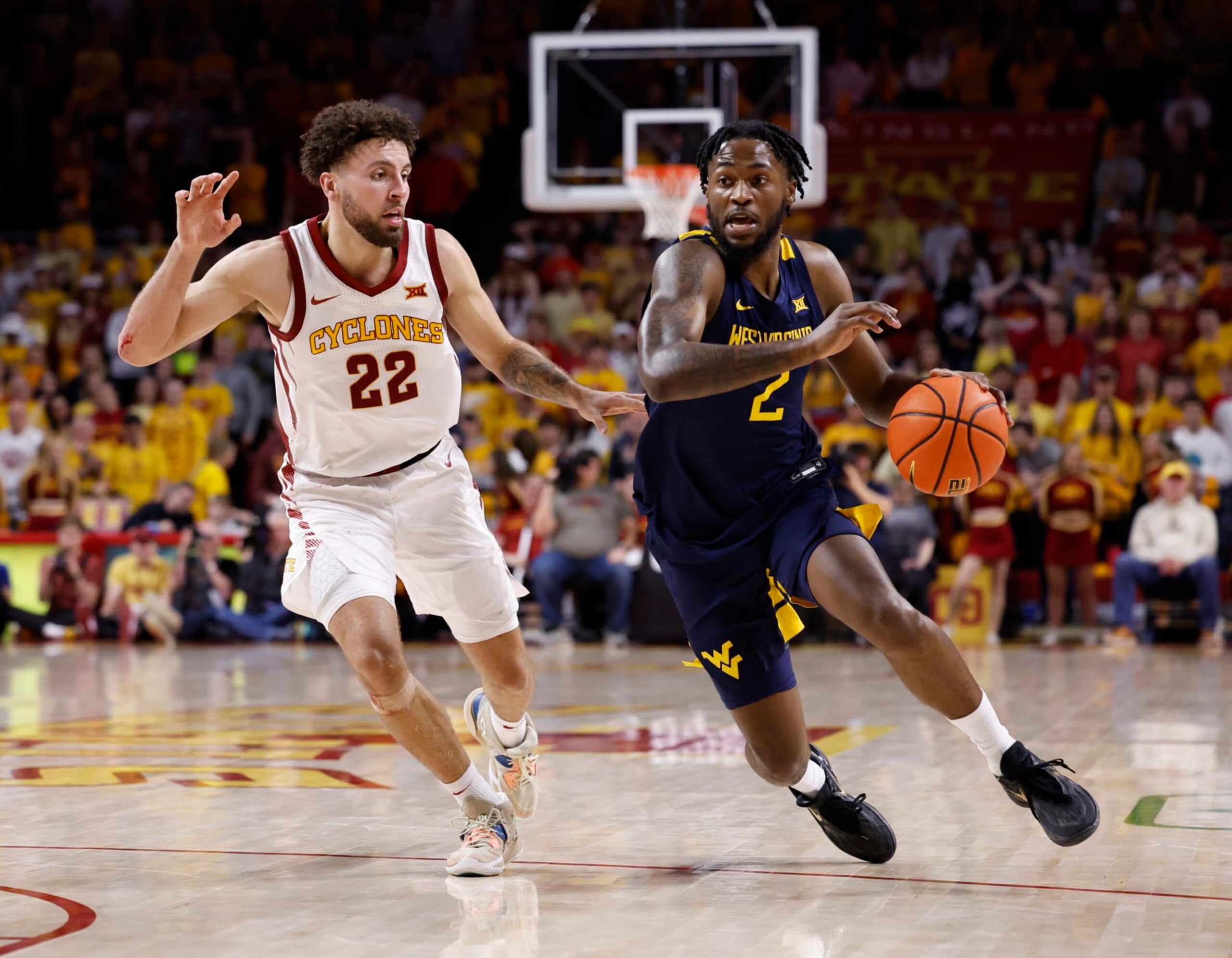 AMES, IA - FEBRUARY 27:  Kobe Johnson #2 of the West Virginia Mountaineers drives the ball as Gabe Kalscheur #22 of the Iowa State Cyclones defends in the second half of play at Hilton Coliseum on February 27, 2023 in Ames, Iowa. The West Virginia Mountaineers won 72-69 over the Iowa State Cyclones. (Photo by David K Purdy/Getty Images)