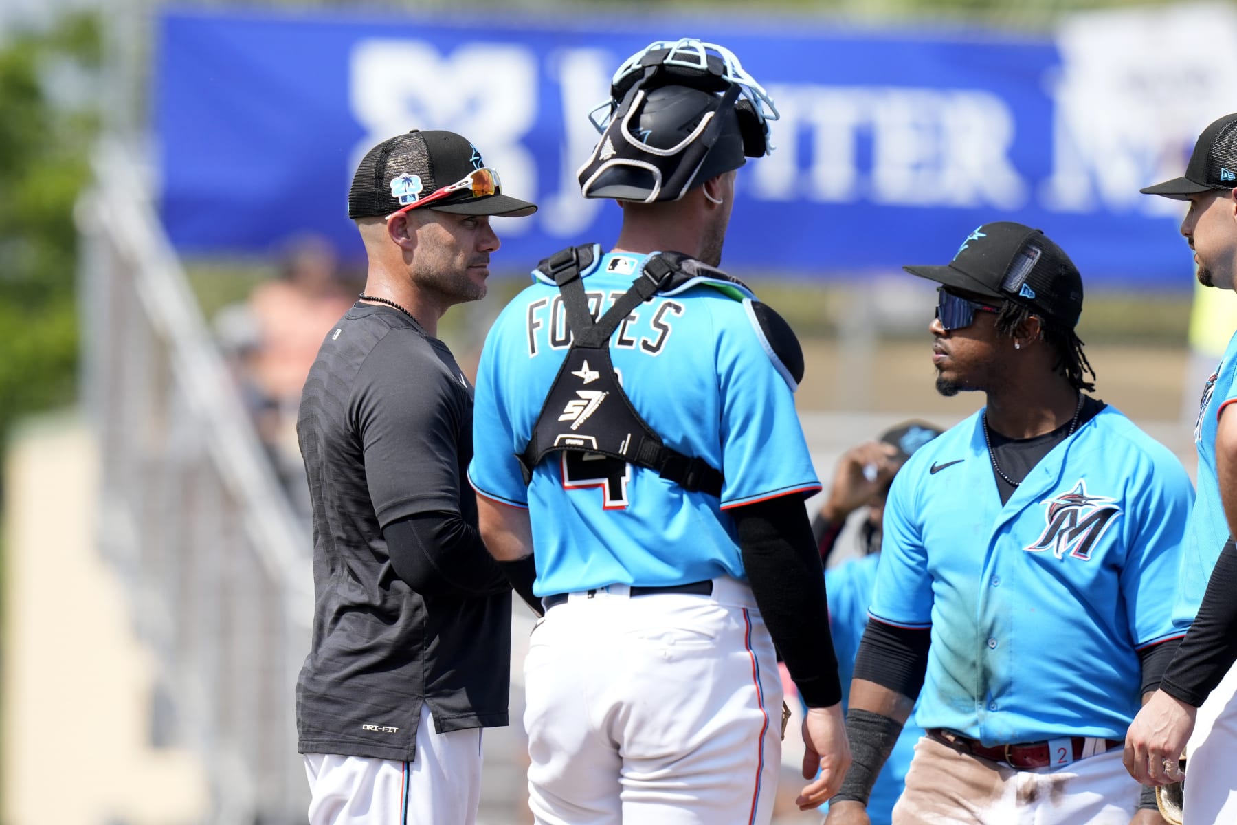 Miami Marlins manager Skip Schumaker, left, stands on the mound with catcher Nick Fortes (4) and relief pitcher George Soriano, right, during the third inning of a spring training baseball game against the New York Mets, Saturday, March 4, 2023, in Jupiter, Fla. (AP Photo/Lynne Sladky)