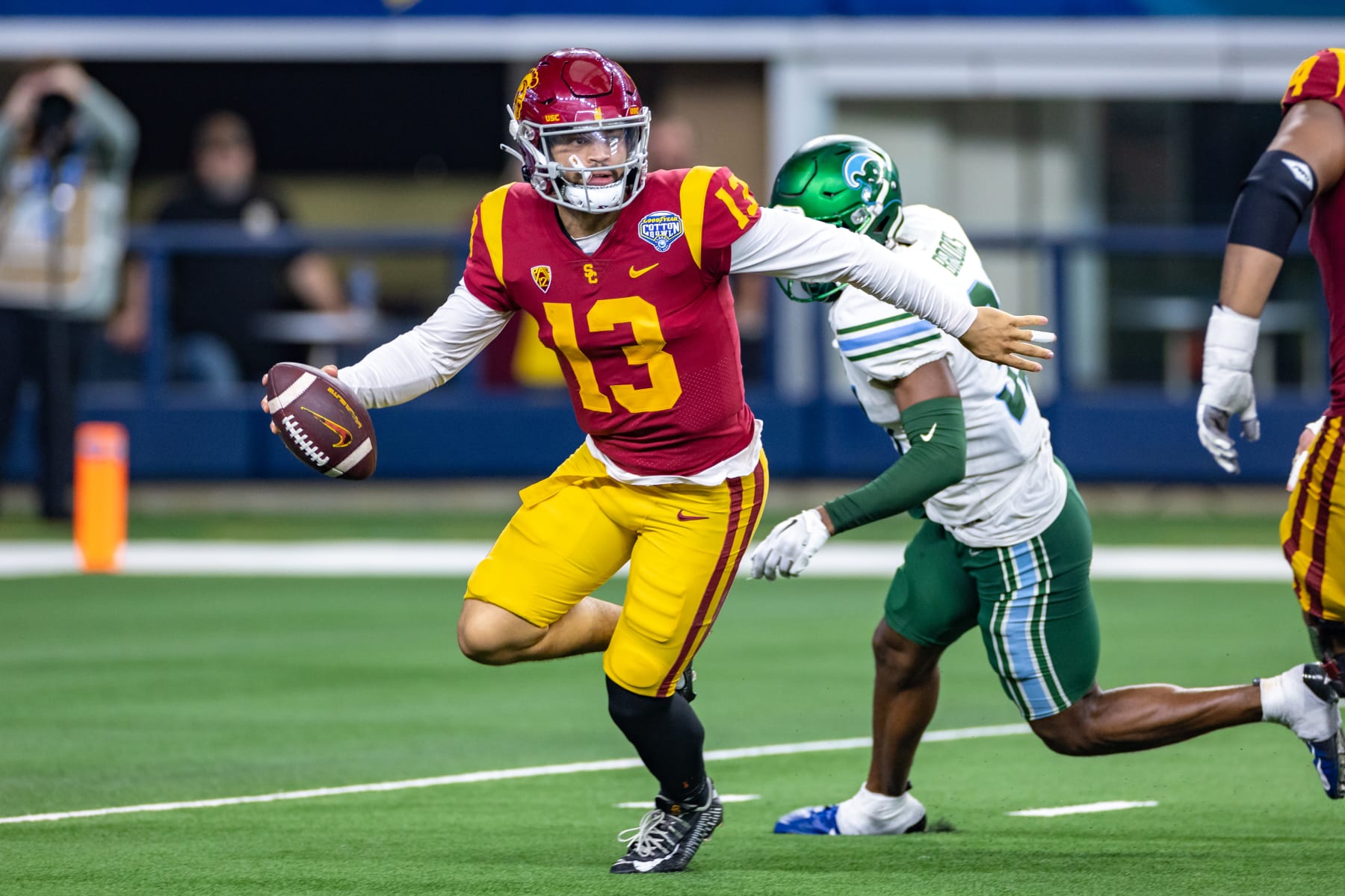 ARLINGTON, TX - JANUARY 02: USC Trojans quarterback Caleb Williams (#13) is flushed out of the pocket by Tulane Green Wave safety Larry Brooks (#31) during the Goodyear Cotton Bowl game between the USC Trojans and Tulane Green Wave on January 02, 2023 at AT&T Stadium in Arlington, TX.  (Photo by Matthew Visinsky/Icon Sportswire via Getty Images)