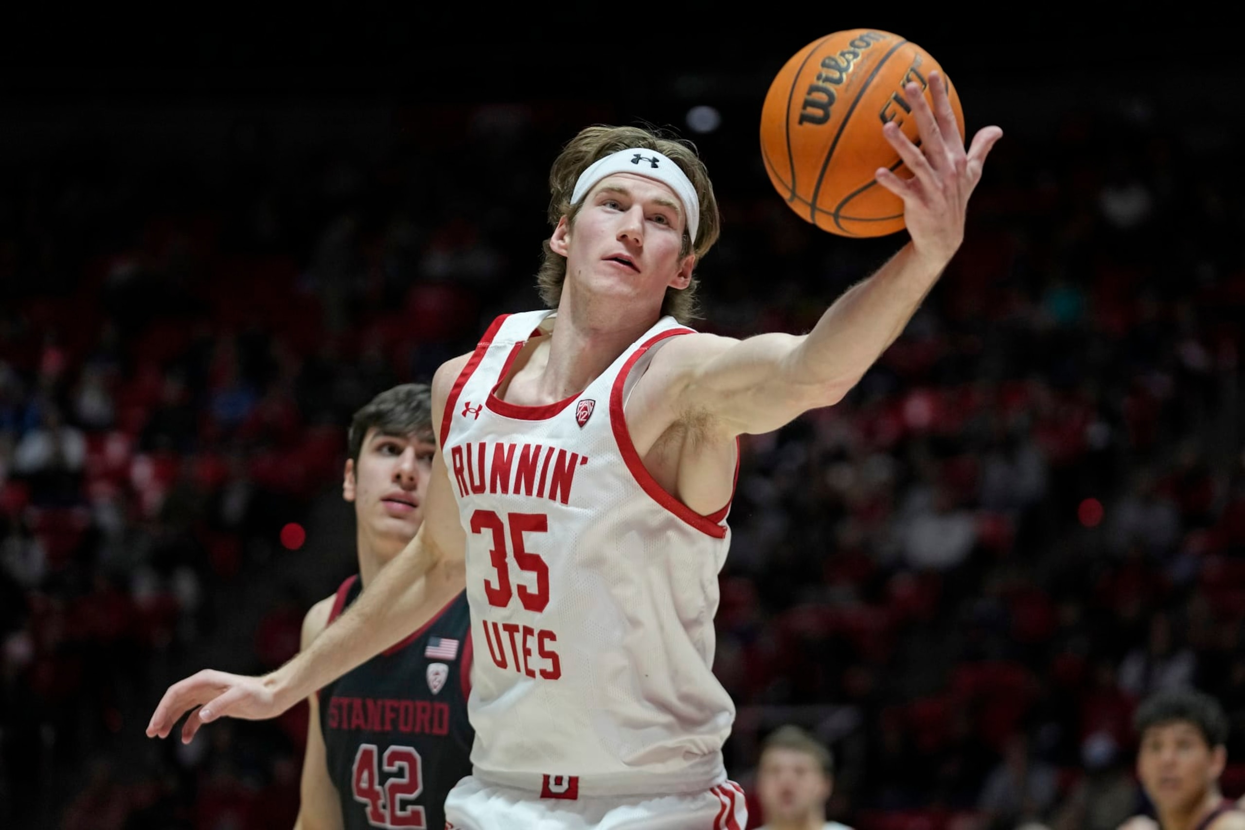 Utah center Branden Carlson (35) reaches for a rebound as Stanford forward Maxime Raynaud (42) looks on during the second half of an NCAA college basketball game, Thursday, Feb. 2, 2023, in Salt Lake City. (AP Photo/Rick Bowmer)