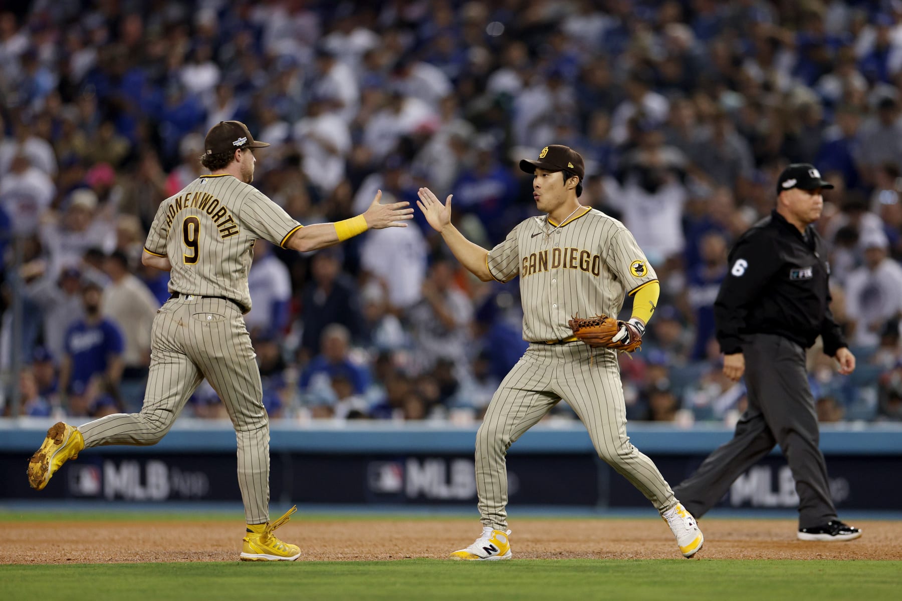 LOS ANGELES, CALIFORNIA - OCTOBER 12: Jake Cronenworth #9 and Ha-Seong Kim #7 of the San Diego Padres celebrate a double play to end the sixth inning in game two of the National League Division Series against the Los Angeles Dodgers at Dodger Stadium on October 12, 2022 in Los Angeles, California. (Photo by Harry How/Getty Images)