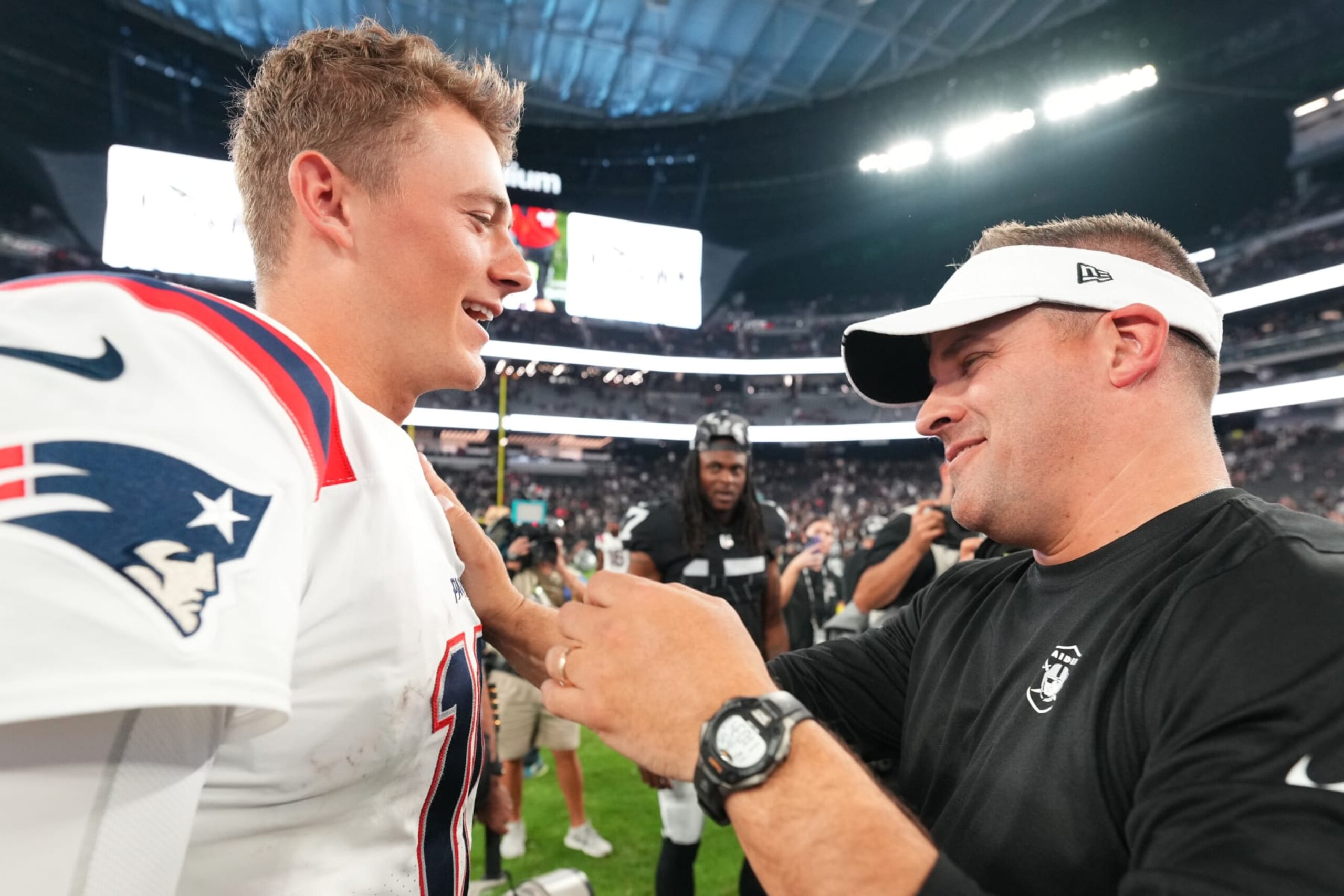 LAS VEGAS, NEVADA - AUGUST 26:  (R-L) Head coach Josh McDaniels of the Las Vegas Raiders and quarterback Mac Jones #10 of the New England Patriots interact after their preseason game at Allegiant Stadium on August 26, 2022 in Las Vegas, Nevada. (Photo by Chris Unger/Getty Images)