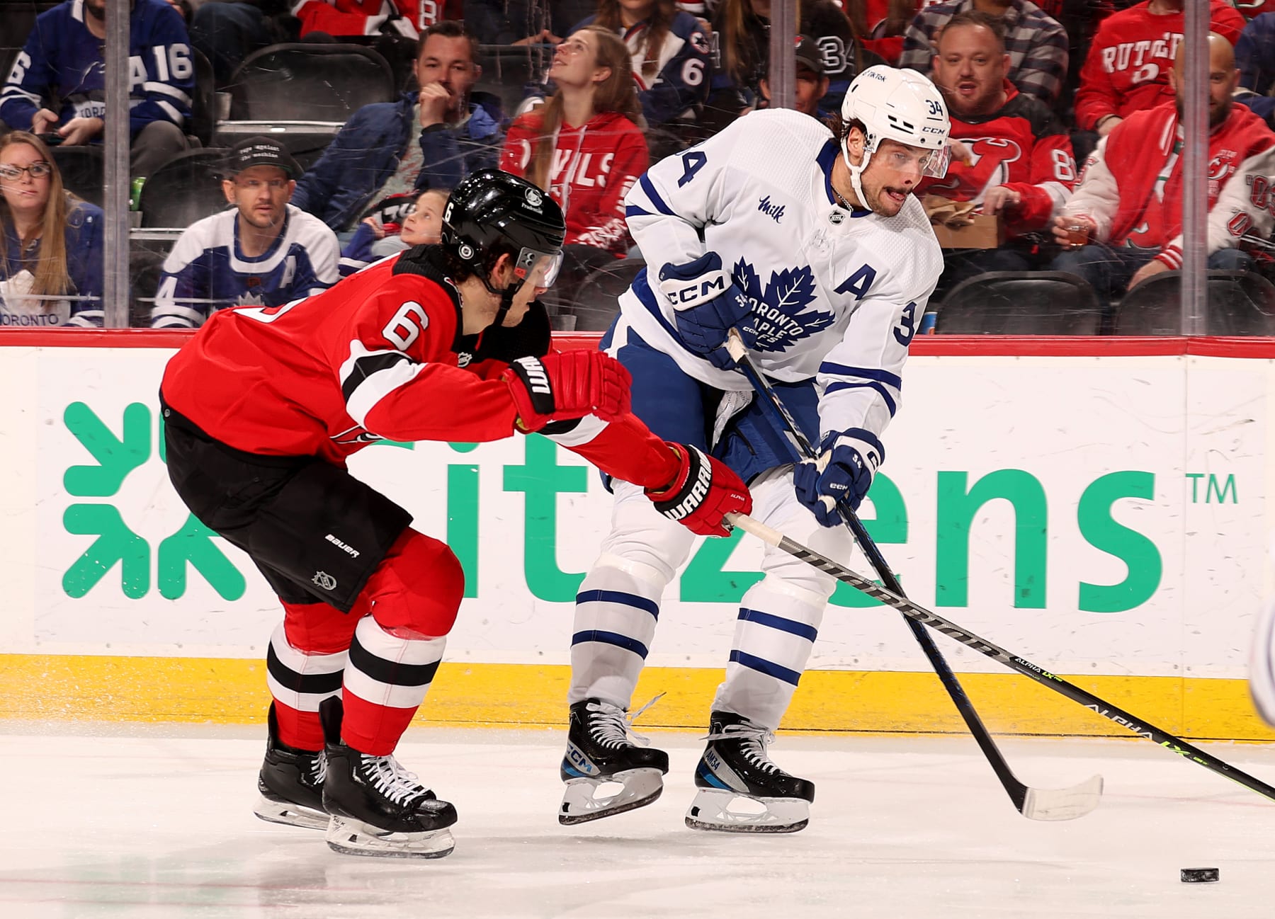 NEWARK, NEW JERSEY - MARCH 07: Auston Matthews #34 of the Toronto Maple Leafs passes the puck as John Marino #6 of the New Jersey Devils defends during the first period at Prudential Center on March 07, 2023 in Newark, New Jersey. (Photo by Elsa/Getty Images)