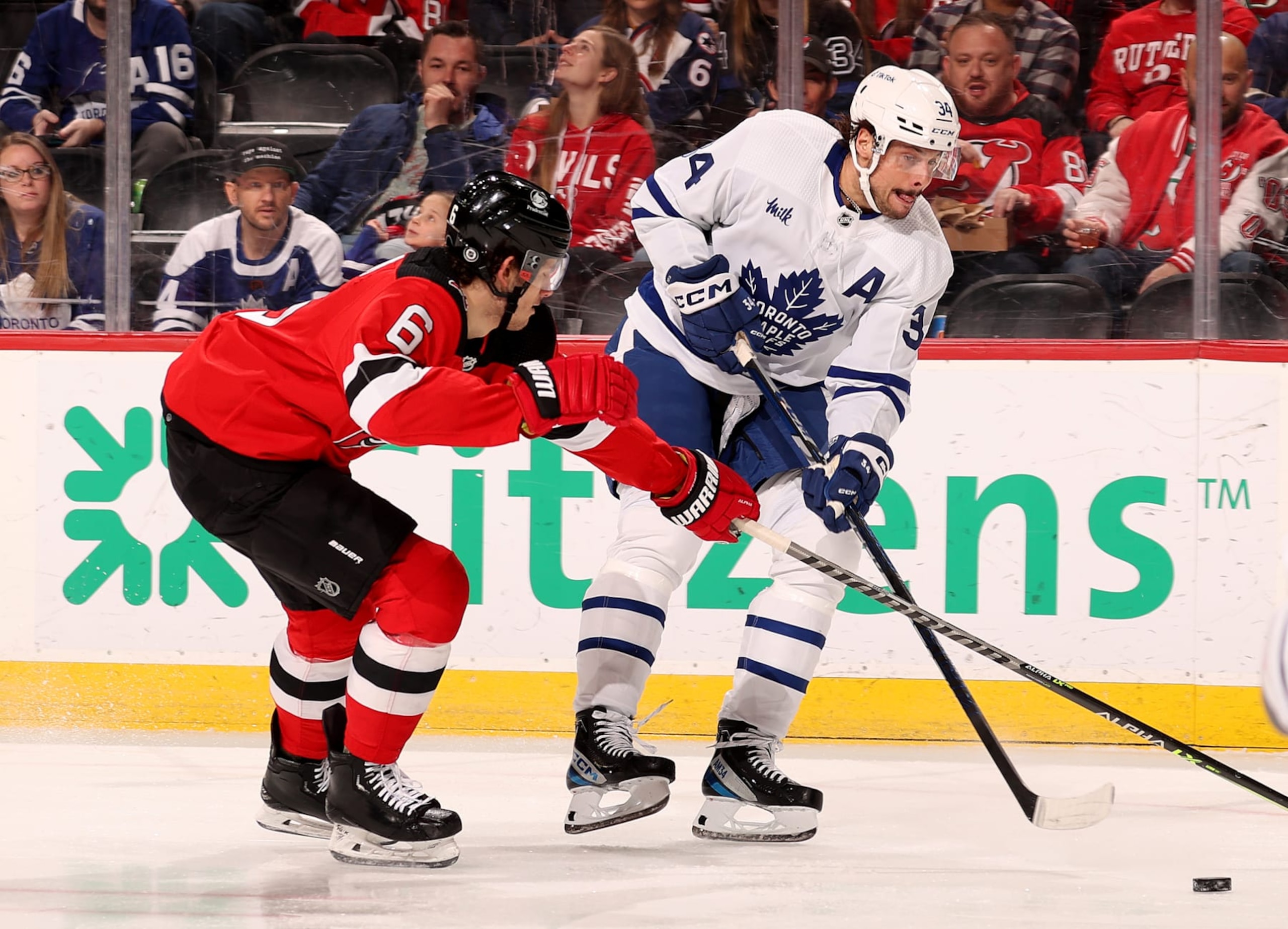 NEWARK, NEW JERSEY - MARCH 07: Auston Matthews #34 of the Toronto Maple Leafs passes the puck as John Marino #6 of the New Jersey Devils defends during the first period at Prudential Center on March 07, 2023 in Newark, New Jersey. (Photo by Elsa/Getty Images)
