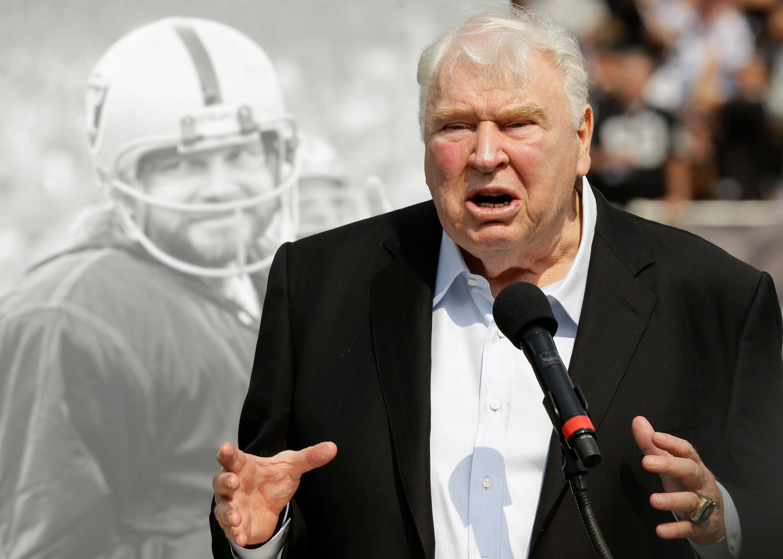 Former Oakland Raiders head coach John Madden speaks about former quarterback Ken Stabler, pictured at rear, at a ceremony honoring Stabler during halftime of an NFL football game between the Raiders and the Cincinnati Bengals in Oakland, Calif., Sunday, Sept. 13, 2015. Staber died in July. (AP Photo/Ben Margot)