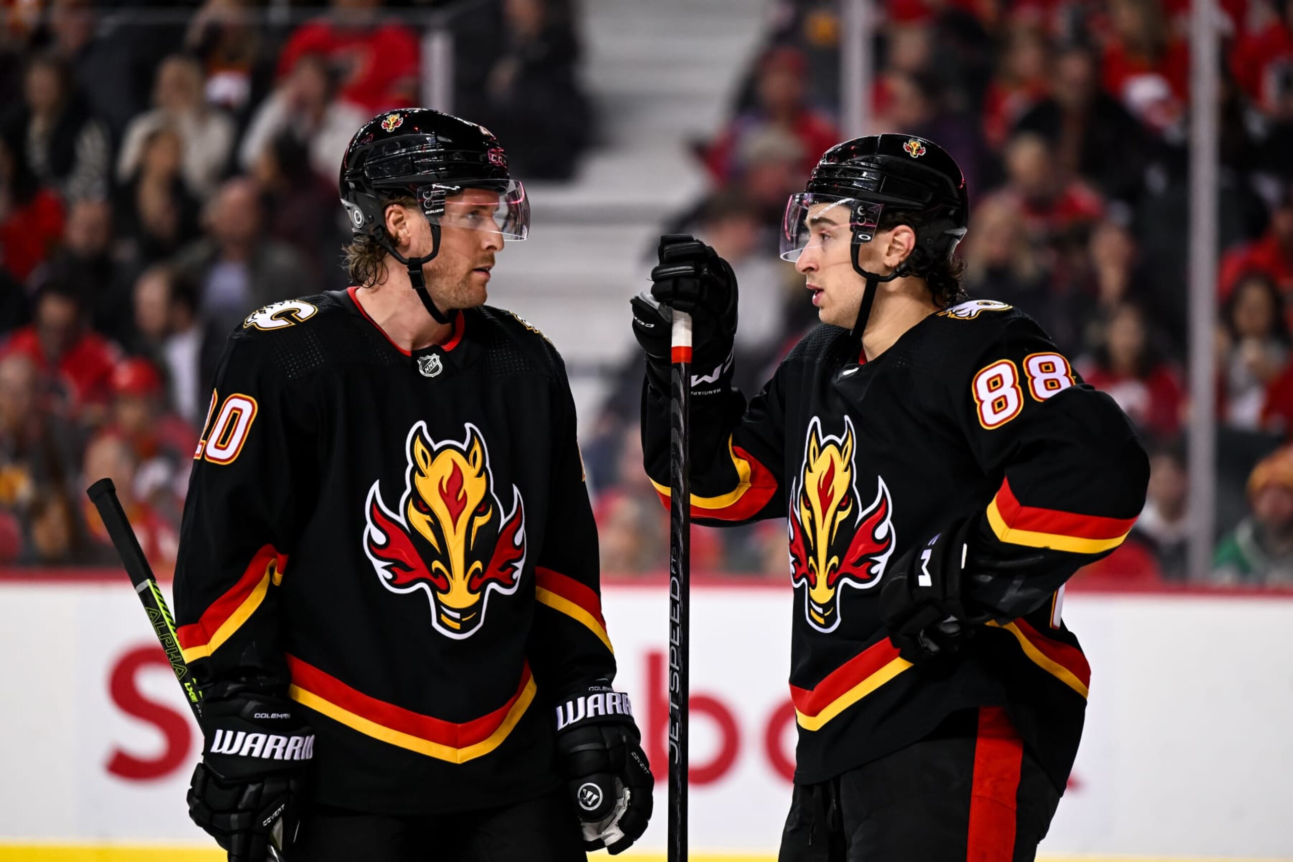 CALGARY, AB - MARCH 04: Calgary Flames Right Wing Blake Coleman (20) and Calgary Flames Left Wing Andrew Mangiapane (88) talk before a face-off during the second period of an NHL game between the Calgary Flames and the Minnesota Wild on March 4, 2023, at the Scotiabank Saddledome in Calgary, AB. (Photo by Brett Holmes/Icon Sportswire via Getty Images)