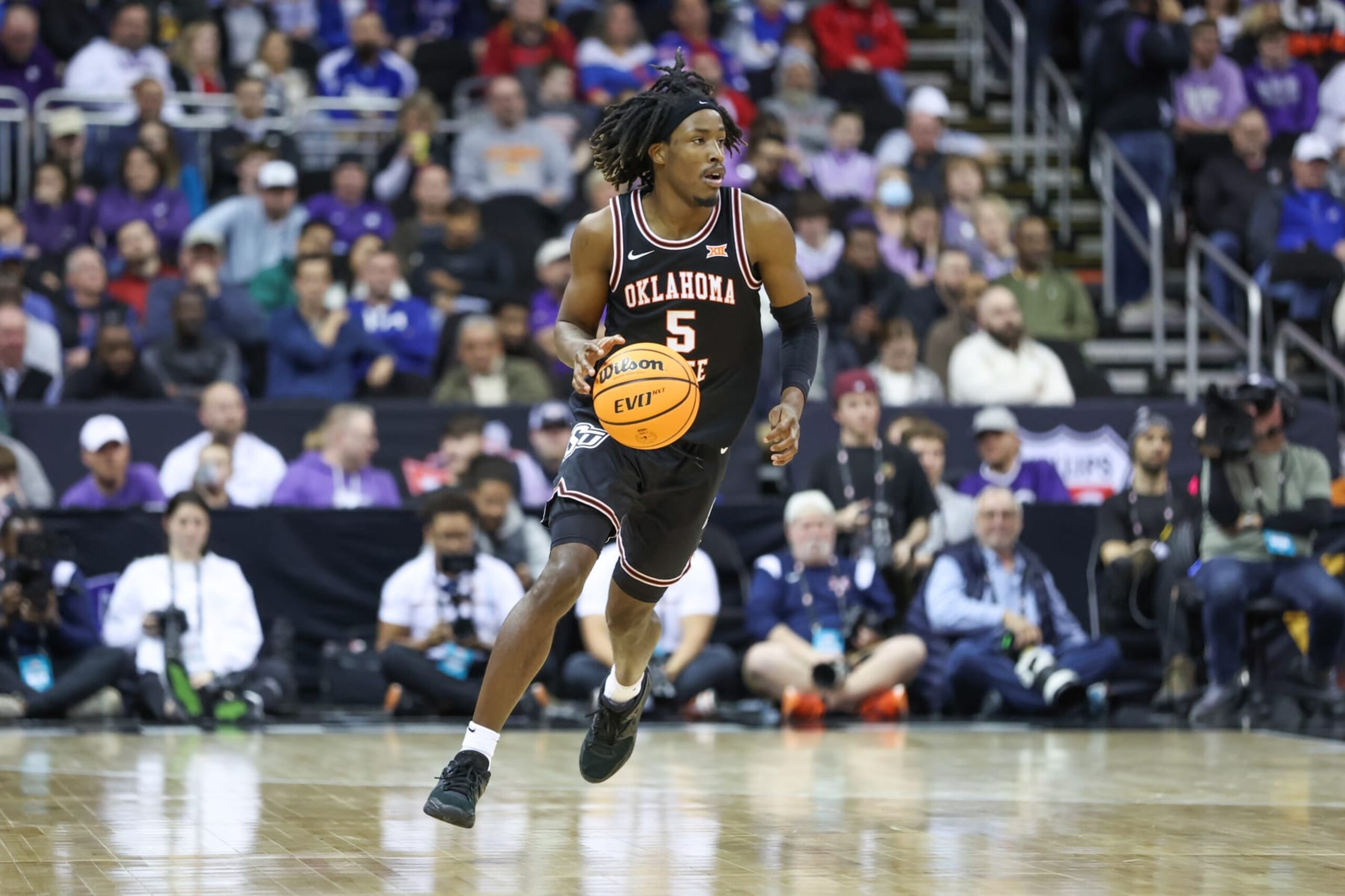 KANSAS CITY, MO - MARCH 09: Oklahoma State Cowboys guard Caleb Asberry (5) brings the ball up court in the second half of a Big 12 Tournament quarterfinal basketball game between the Oklahoma State Cowboys and Texas Longhorns on March 9, 2023 at T-Mobile Center in Kansas City, MO. (Photo by Scott Winters/Icon Sportswire via Getty Images)