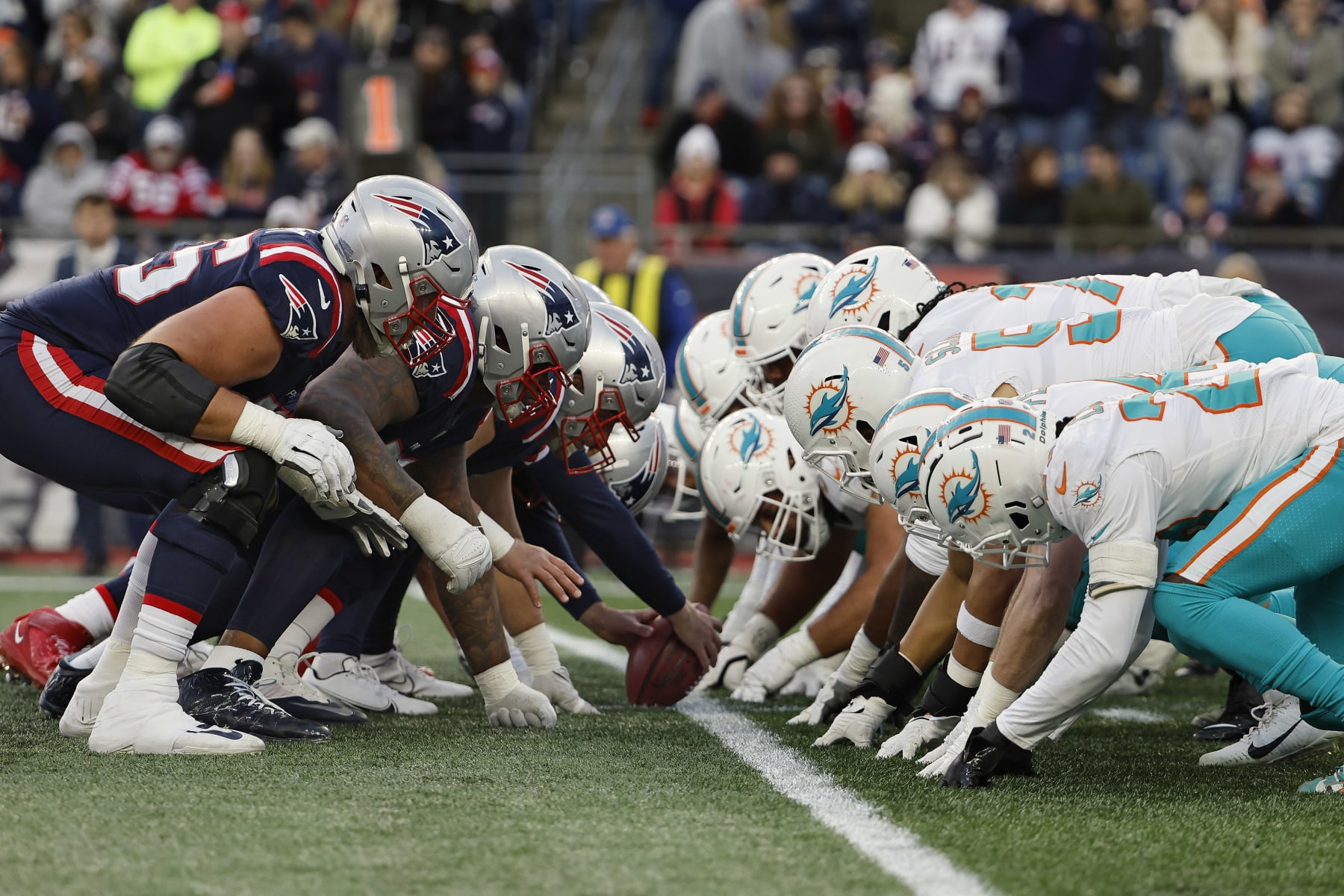 FOXBOROUGH, MASSACHUSETTS - JANUARY 01: The Miami Dolphins and the New England Patriots line up for the snap at the line of scrimmage during the game at Gillette Stadium on January 01, 2023 in Foxborough, Massachusetts. (Photo by Winslow Townson/Getty Images)