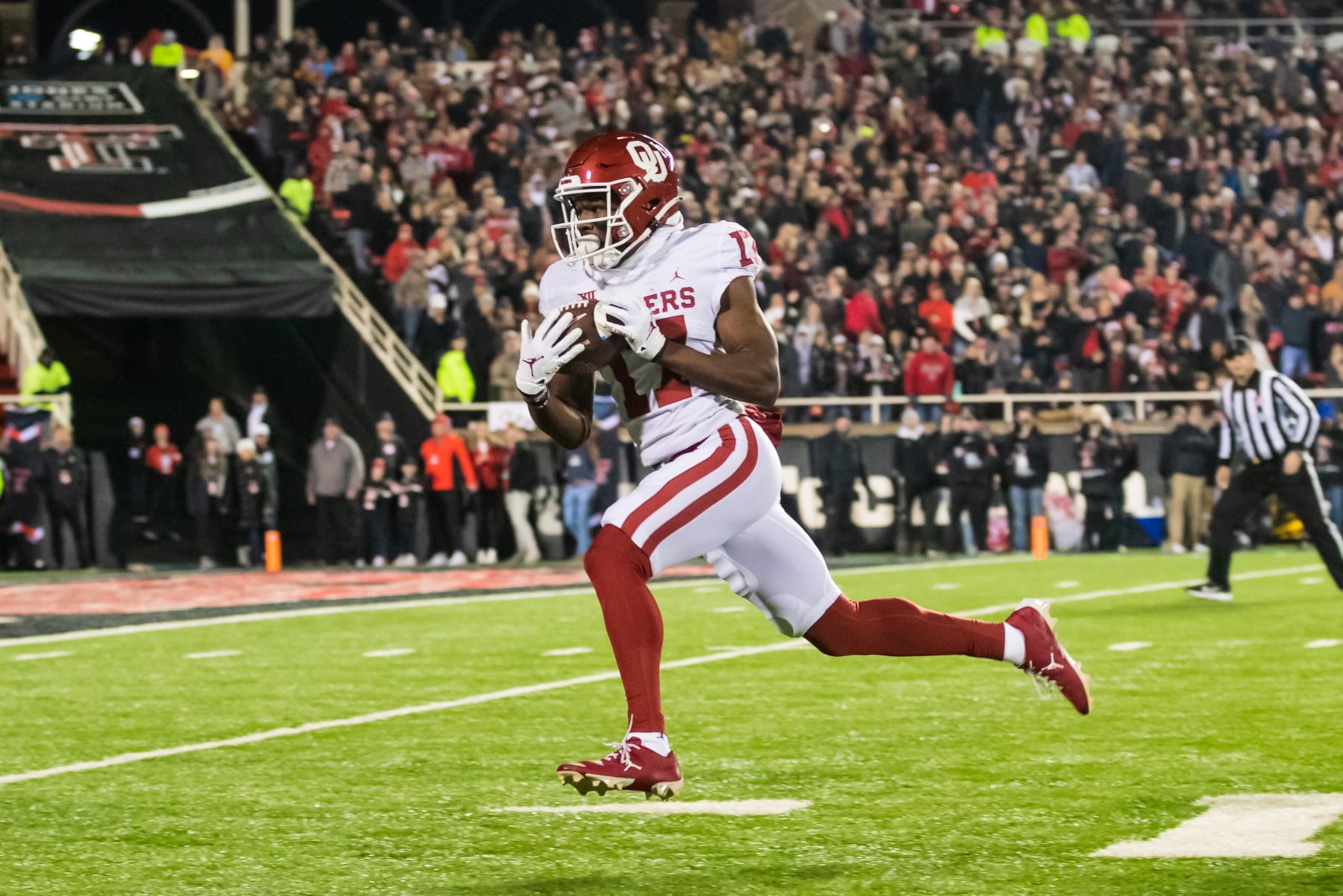 LUBBOCK, TEXAS - NOVEMBER 26: Wide receiver Marvin Mims Jr. #17 of the Oklahoma Sooners runs for a touchdown during the first half against the Texas Tech Red Raiders at Jones AT&T Stadium on November 26, 2022 in Lubbock, Texas. (Photo by John E. Moore III/Getty Images)