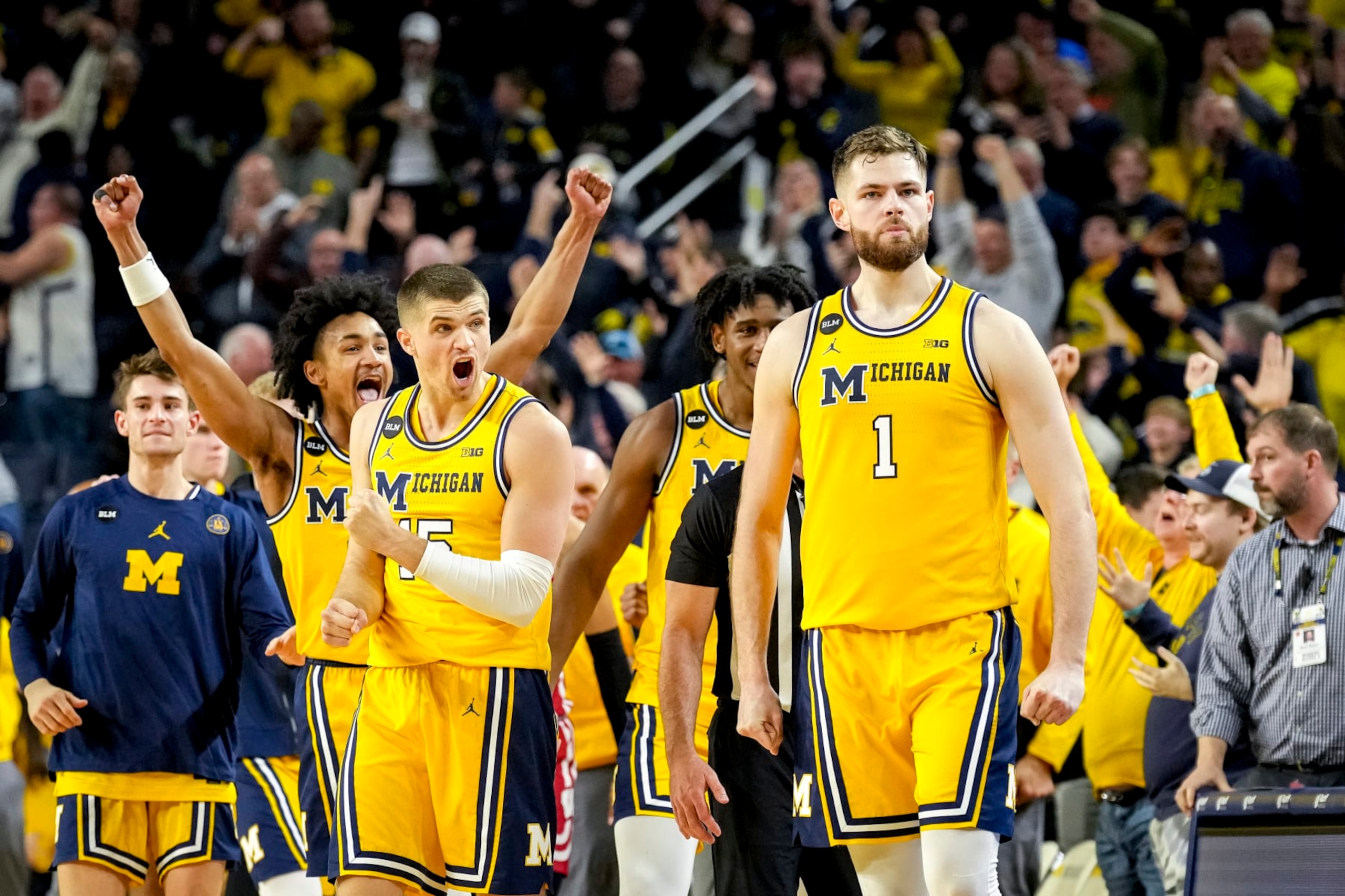 ANN ARBOR, MICHIGAN - FEBRUARY 26: Kobe Bufkin #2 and Joey Baker #15 of the Michigan Wolverines react after Hunter Dickinson #1 of the Michigan Wolverines made a shot that forced the game into overtime against the Wisconsin Badgers during the second half at Crisler Arena on February 26, 2023 in Ann Arbor, Michigan. (Photo by Nic Antaya/Getty Images)