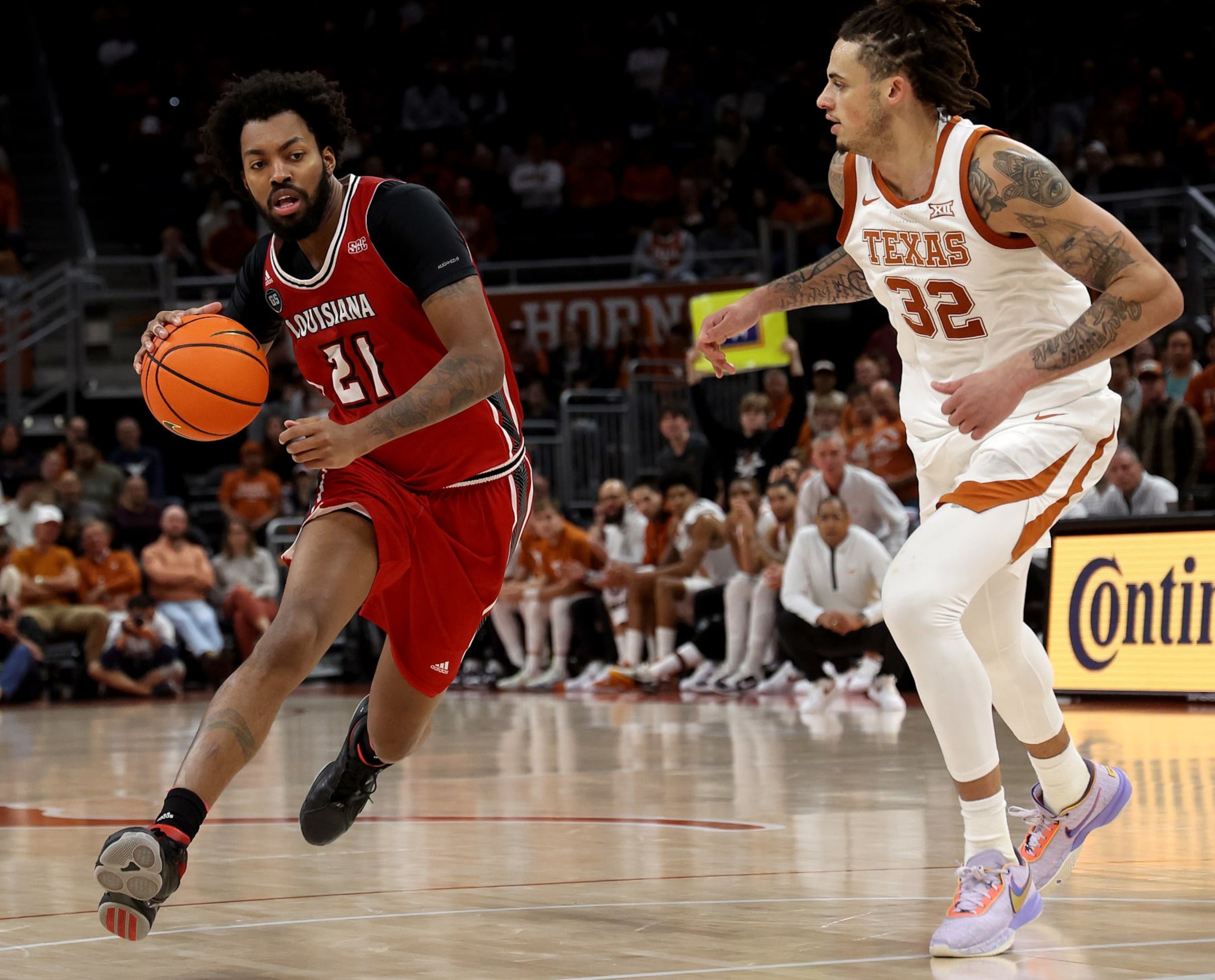 AUSTIN, TEXAS - DECEMBER 21: Jordan Brown #21 of the Louisiana Lafayette Ragin Cajuns drives around Christian Bishop #32 of the Texas Longhorns during the game the between the Texas Longhorns and the Louisiana Lafayette Ragin Cajuns at Moody Center on December 21, 2022 in Austin, Texas. (Photo by Chris Covatta/Getty Images)