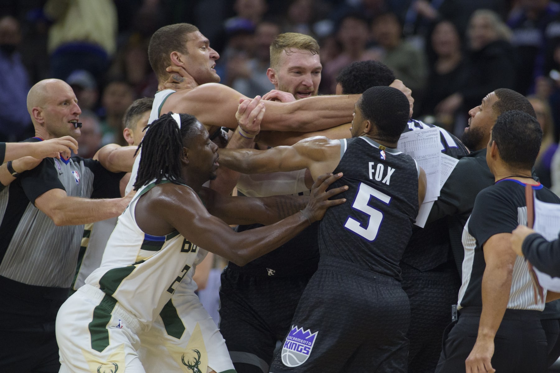 Milwaukee Bucks center Brook Lopez, left scuffles with Sacramento Kings forward Trey Lyles as members of both teams intervene in the final seconds of the second half of an NBA basketball game in Sacramento, Calif., Monday, March 13, 2023. Lopez and Lyles were both ejected from the game. The Bucks won 133-124. (AP Photo/Randall Benton)