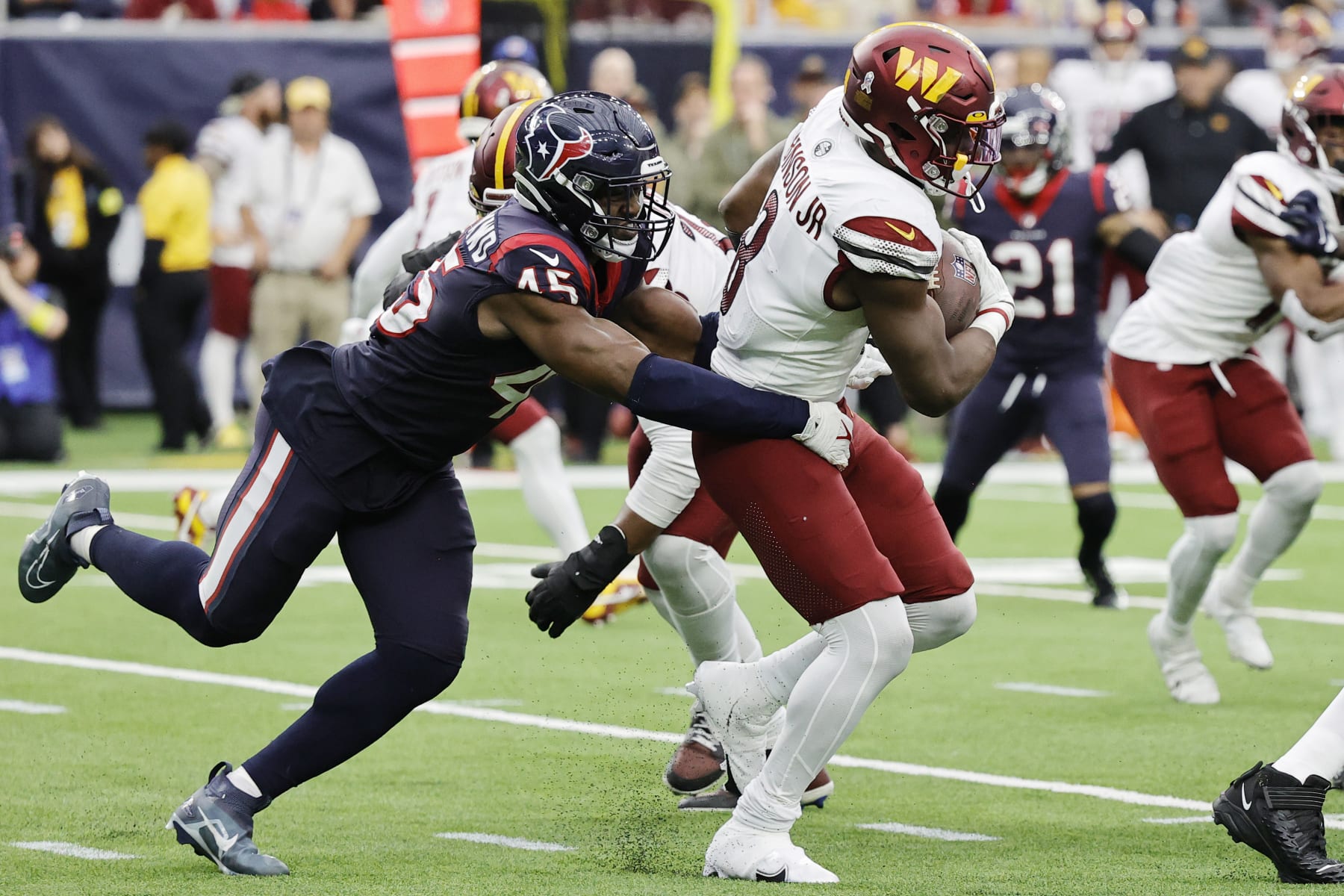HOUSTON, TEXAS - NOVEMBER 20: Brian Robinson Jr. #8 of the Washington Commanders gets tackled by Ogbonnia Okoronkwo #45 of the Houston Texans in the fourth quarter at NRG Stadium on November 20, 2022 in Houston, Texas. (Photo by Bob Levey/Getty Images)
