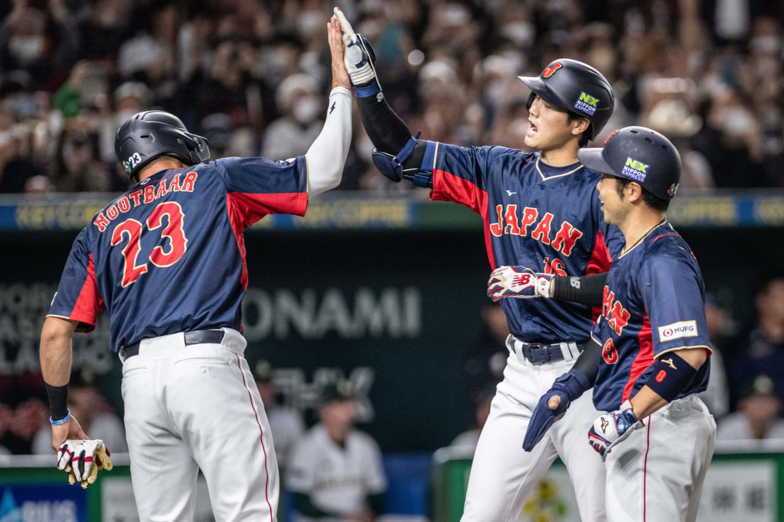 Japan's Shohei Ohtani (C) highfives with Lars Nootbaar highfive after hitting a three-run home run during the World Baseball Classic (WBC) Pool B round game between Japan and Australia at the Tokyo Dome in Tokyo on March 12, 2023. (Photo by Yuichi YAMAZAKI / AFP) (Photo by YUICHI YAMAZAKI/AFP via Getty Images)