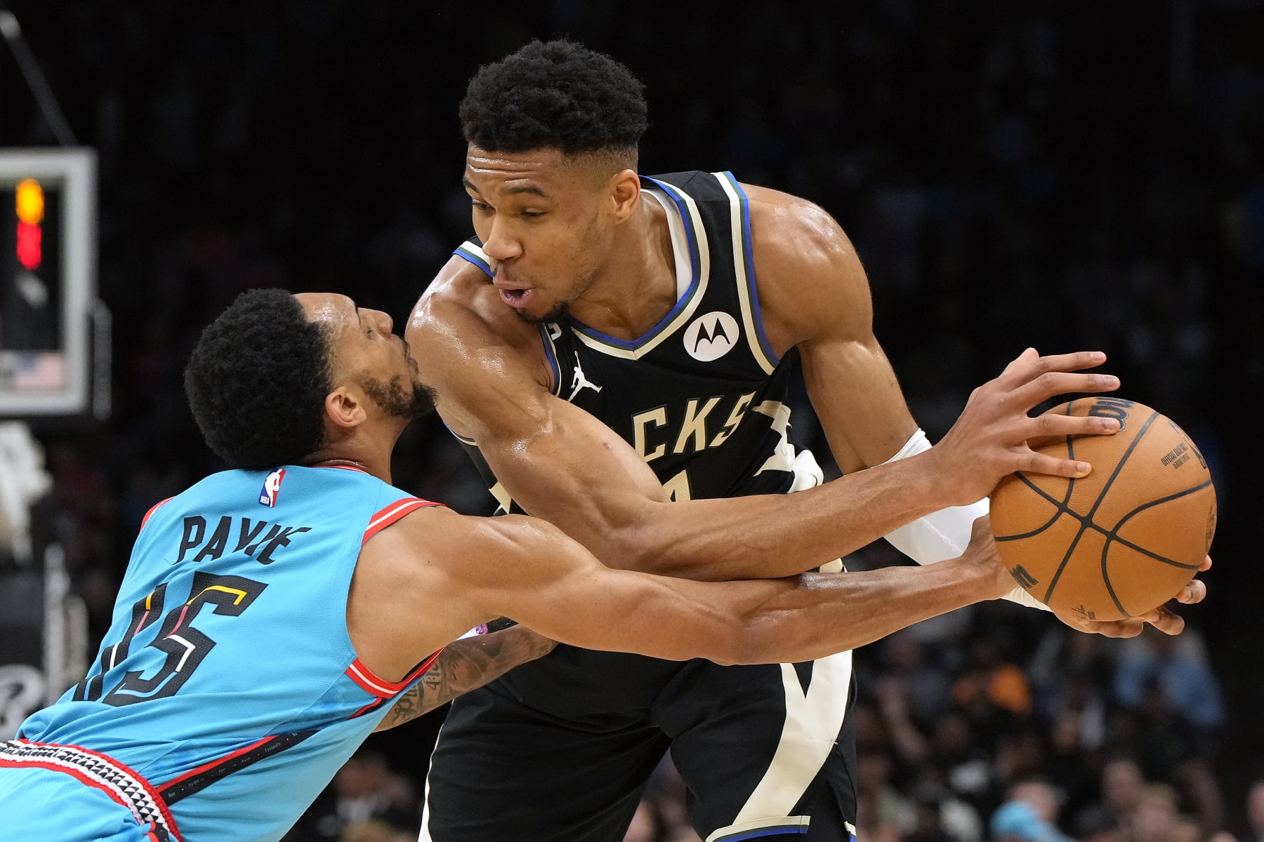 Phoenix Suns guard Cameron Payne (15) reaches for the ball held by Milwaukee Bucks forward Giannis Antetokounmpo (34) during the first half of an NBA basketball game Tuesday, March 14, 2023, in Phoenix. (AP Photo/Rick Scuteri)
